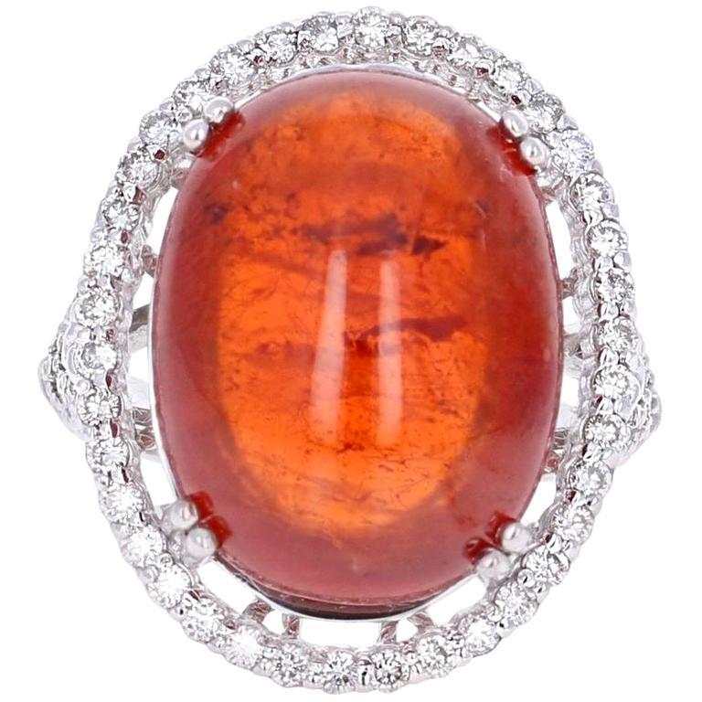 This beautiful ring has a 26.12 carat Cabochon Spessartine set in the center of the ring. A Spessartine is a natural stone that is actually a part of the Garnet family of stones. The ring is surrounded by 52 Round Brilliant Cut Diamonds that weigh