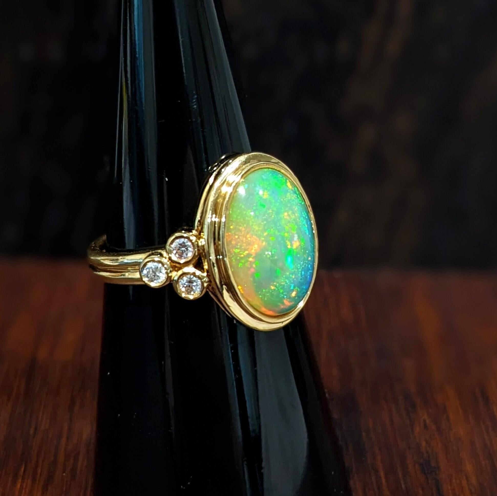 This lovely opal has all the colors of the rainbow, accented with 6 natural earth mined diamonds and beautiful double shank. This glowing oval ring is perfect for the modern bride or that special someone in your life! This opal ring also makes a