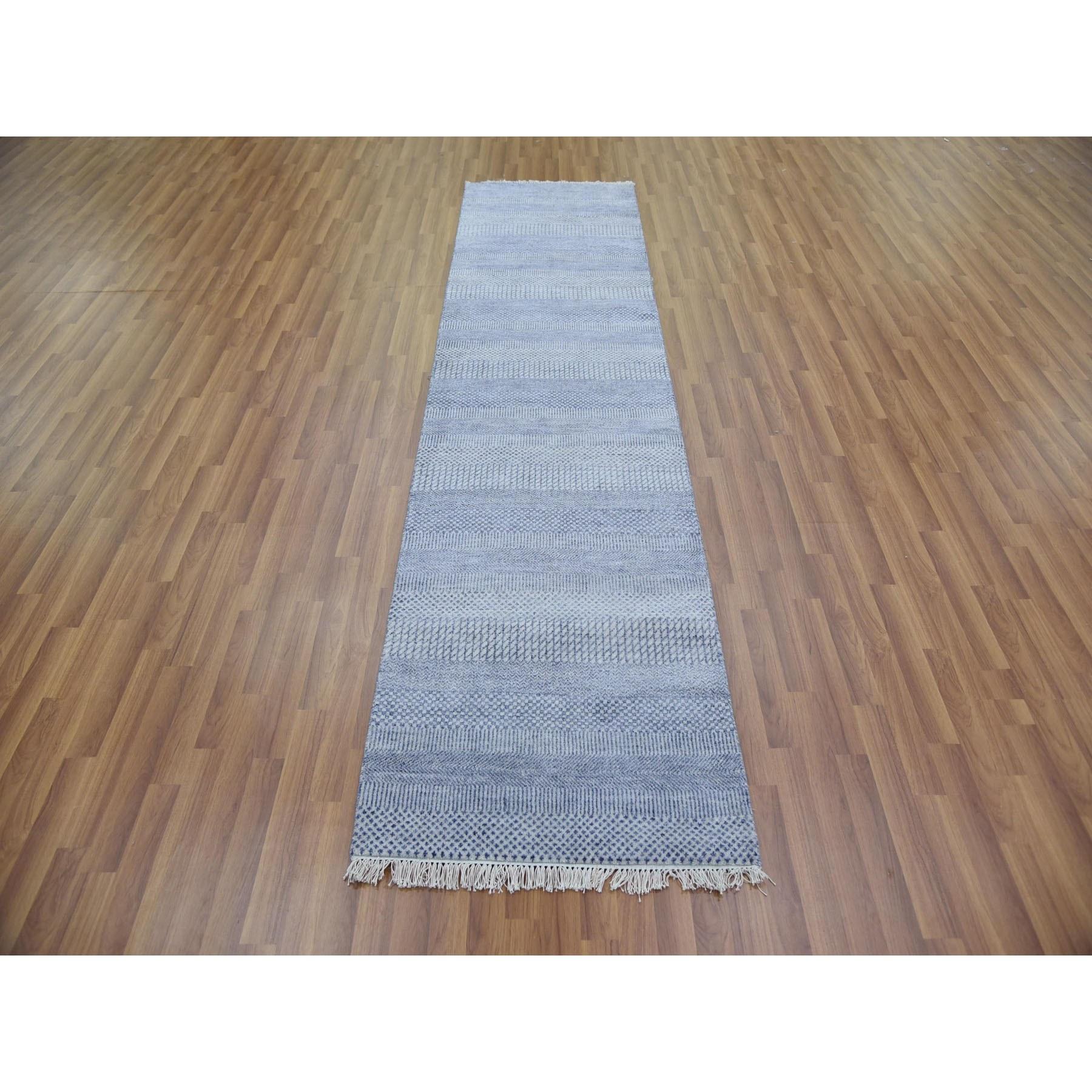 Il s'agit d'un véritable tapis d'Orient, unique en son genre, bleu argenté, noué à la main, au motif moderne d'herbes, en laine et soie densément tissées. Il a été noué pendant des mois et des mois selon des techniques de tissage séculaires par des