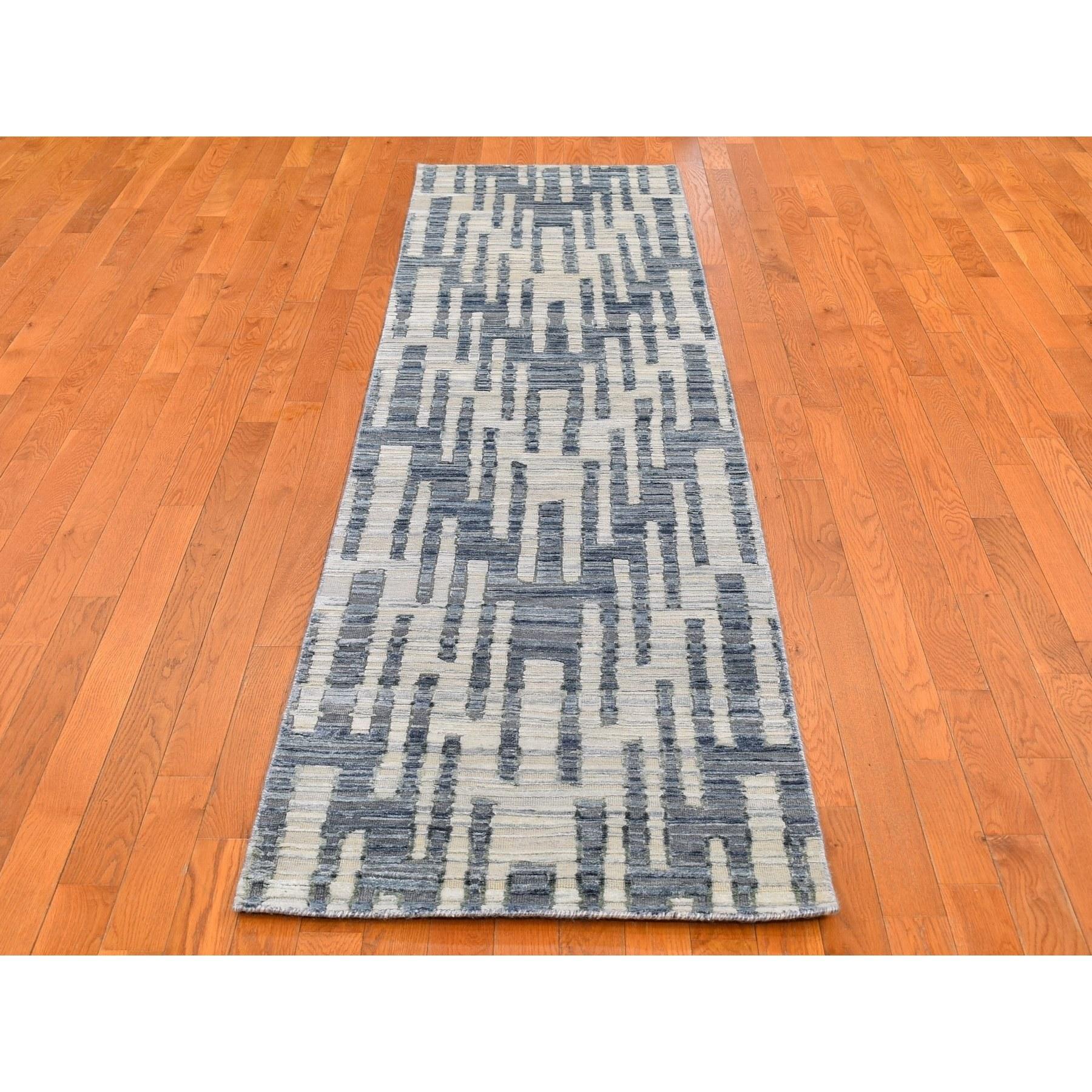 Il s'agit d'un véritable tapis d'Orient noué à la main, unique en son genre, en pure soie bleue et laine texturée, avec des motifs en zigzag et des graphes. Il a été tissé pendant des mois et des mois selon les techniques séculaires de l'artisanat