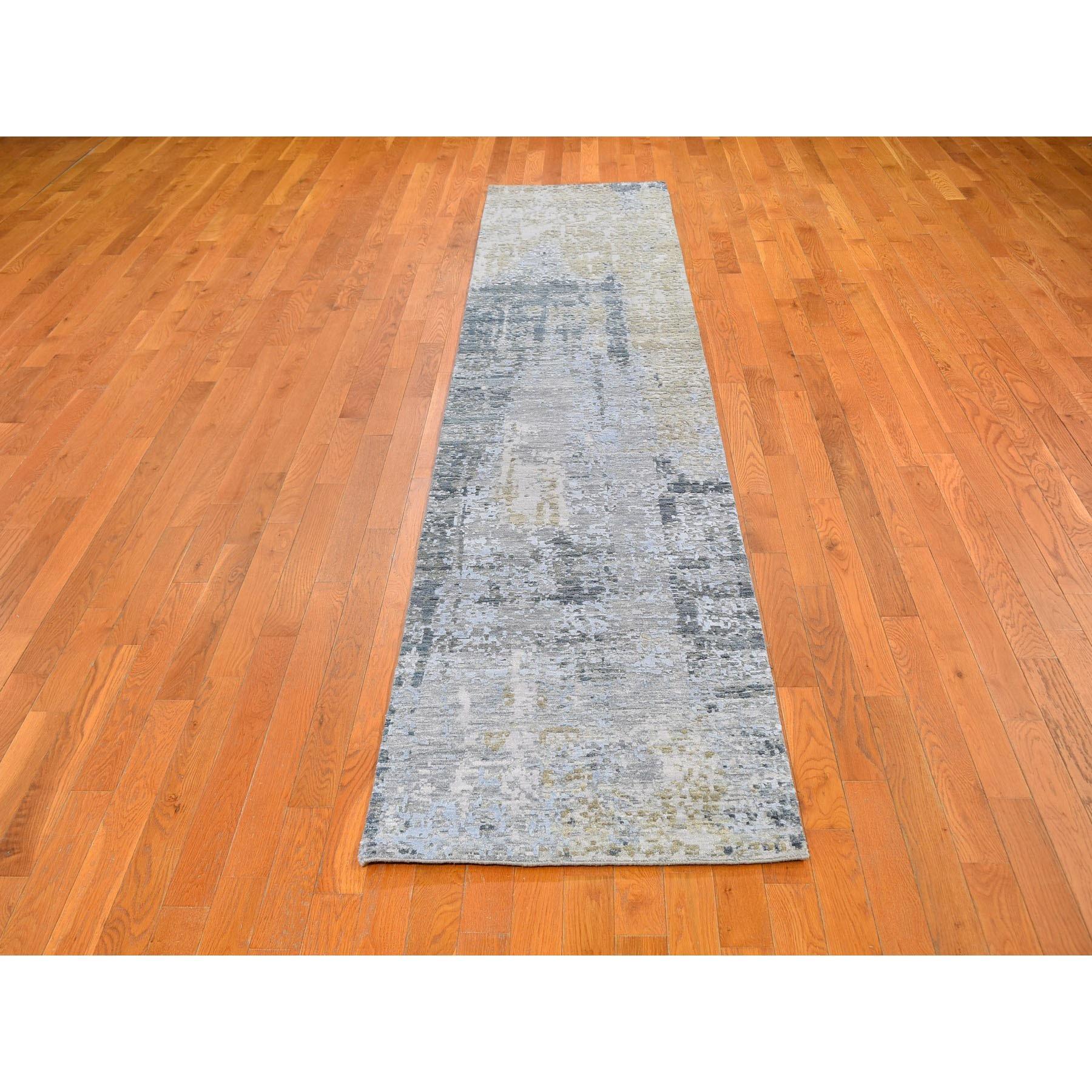 Il s'agit d'un véritable tapis d'Orient noué à la main, unique en son genre, en laine et soie à motif abstrait bleu argenté, à poils ras et à tissage dense. Il a été tissé pendant des mois et des mois selon les techniques séculaires de l'artisanat