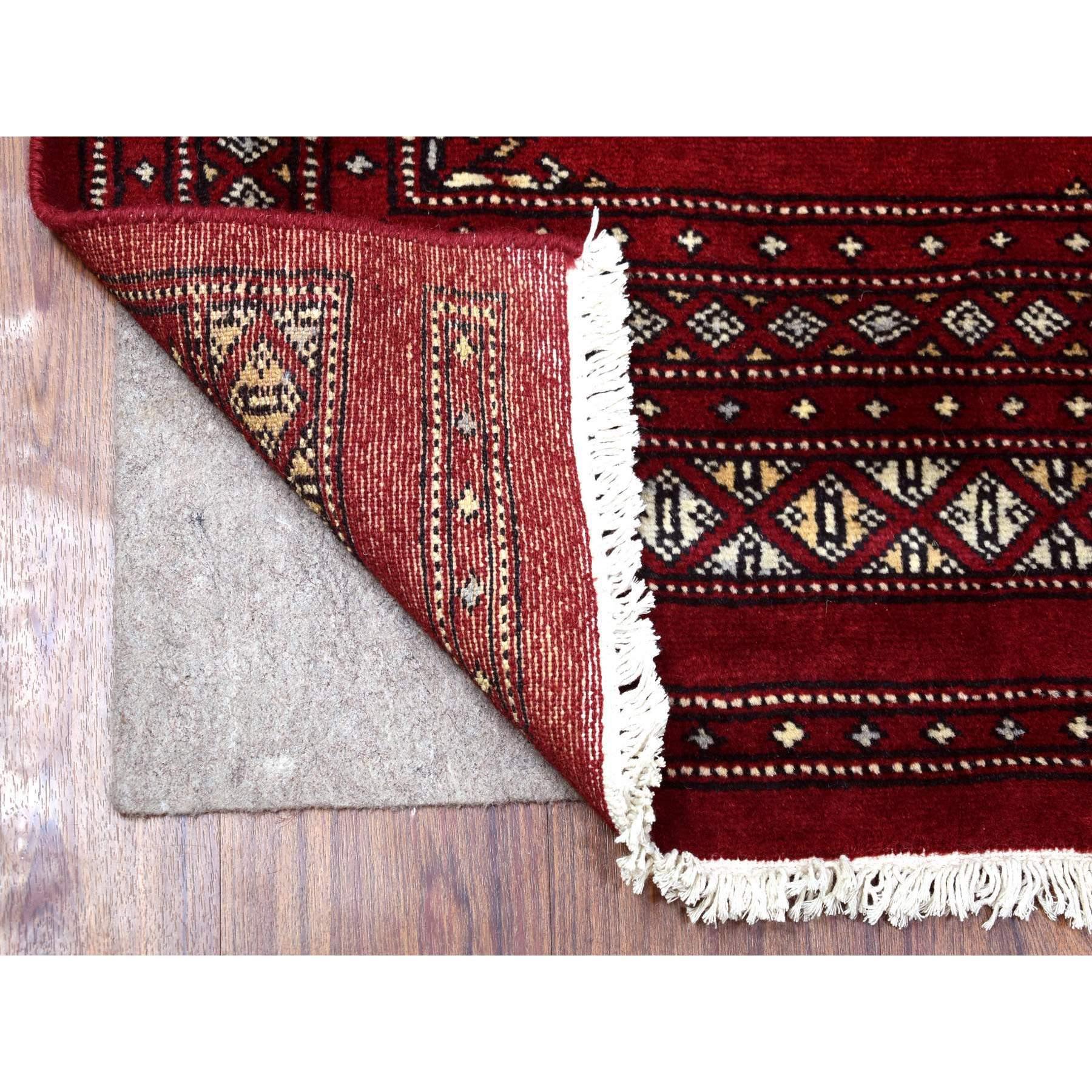 This is a truly genuine one-of-a-kind Mori Bokara with Tribal Medallions Design Deep and Rich Red Extra Soft Wool Hand Knotted Oriental Runner Rug. It has been Knotted for months and months in the centuries-old weaving craftsmanship techniques by