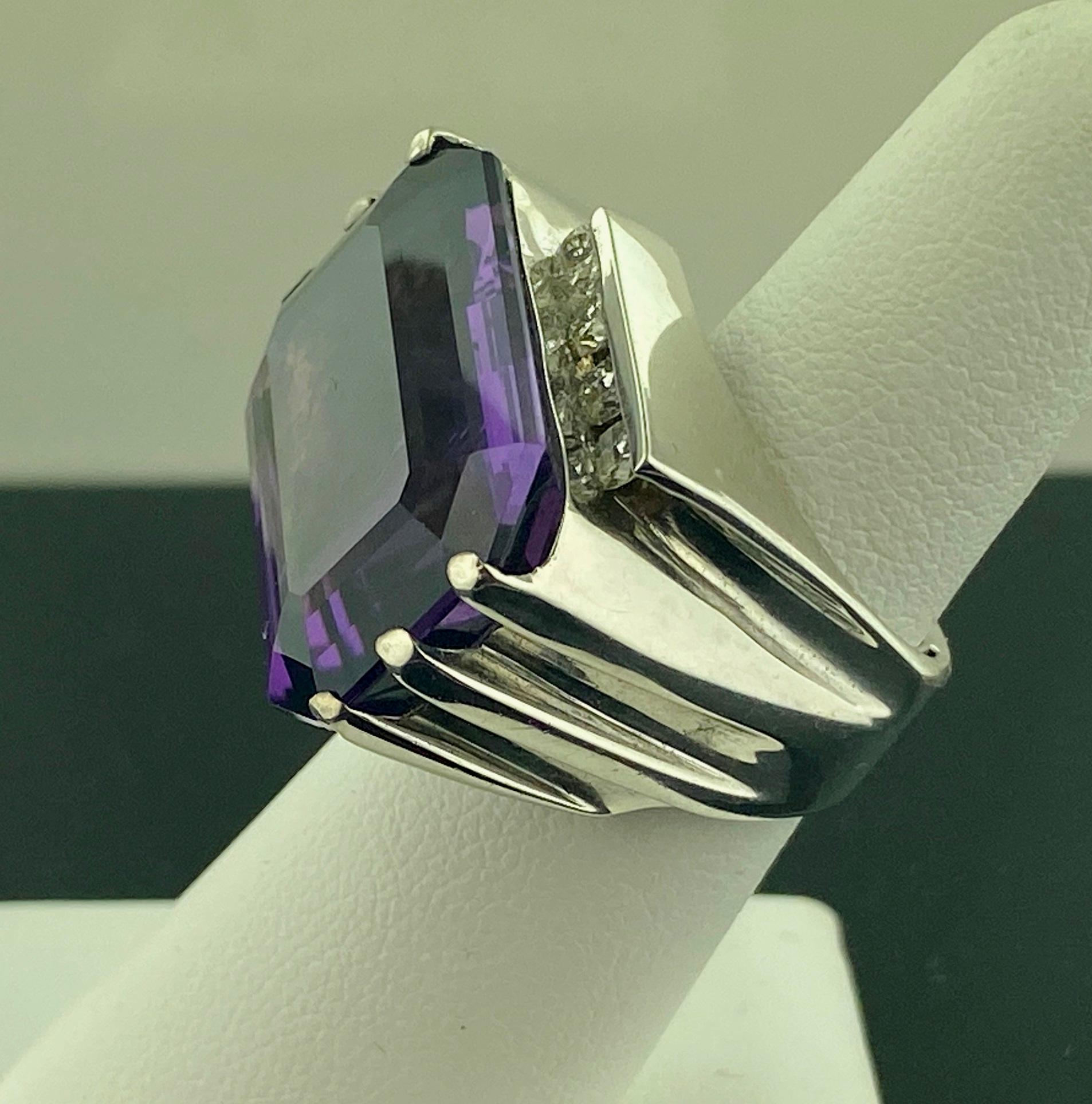 Set in 18 karat white gold, weighing 28 grams, is one Emerald Cut 27 carat Amethyst with 8 Round Brilliant Cut diamonds weighing approximately 0.80 carats, Color: G, Clarity: VS-1.  Ring size is 6.5.