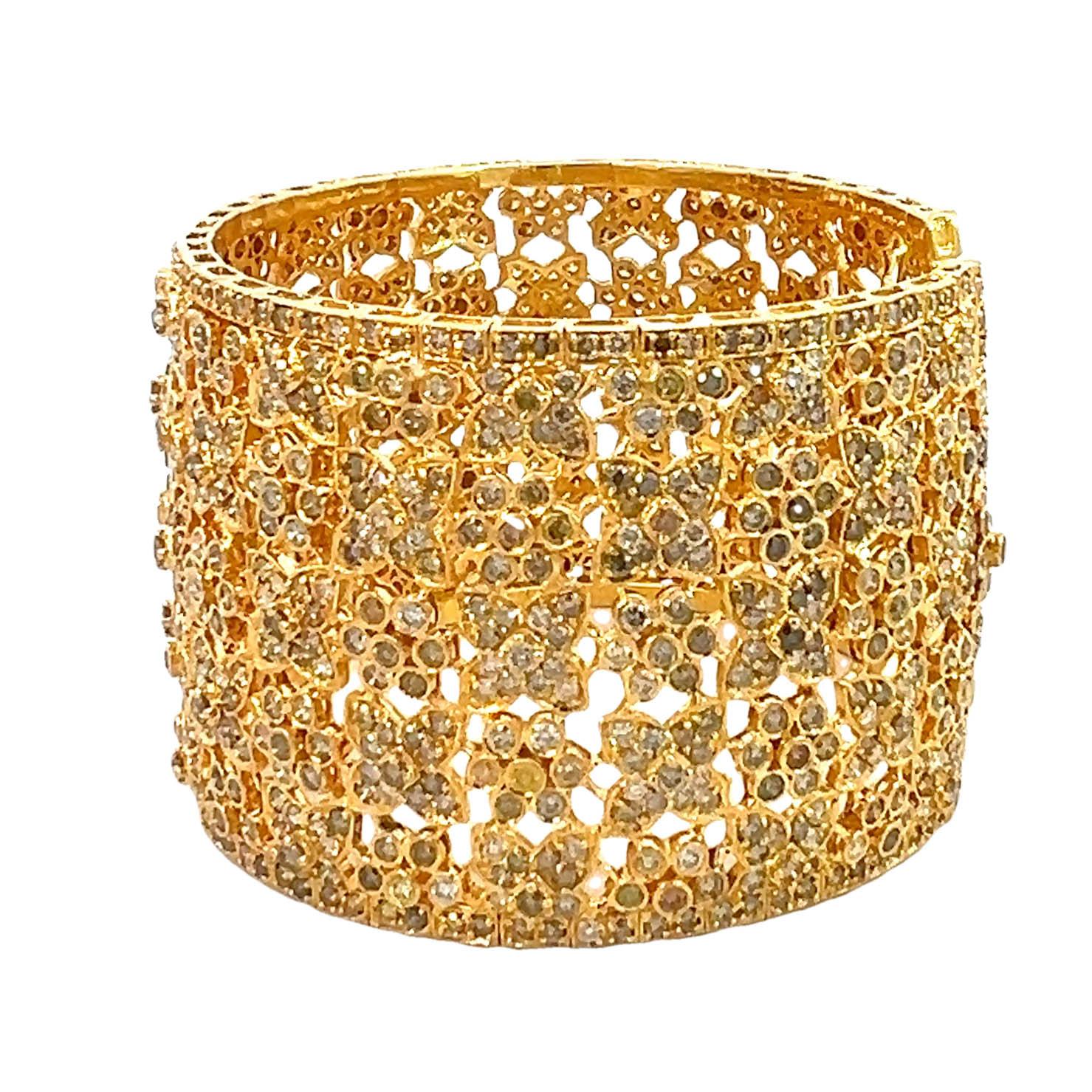 Questo eccezionale bracciale largo con diamanti mette in mostra una serie mozzafiato di diamanti colorati per un totale di 27 carati, incastonati in uno squisito oro giallo da 18 carati. L'intricato design a reticolo è impreziosito da un