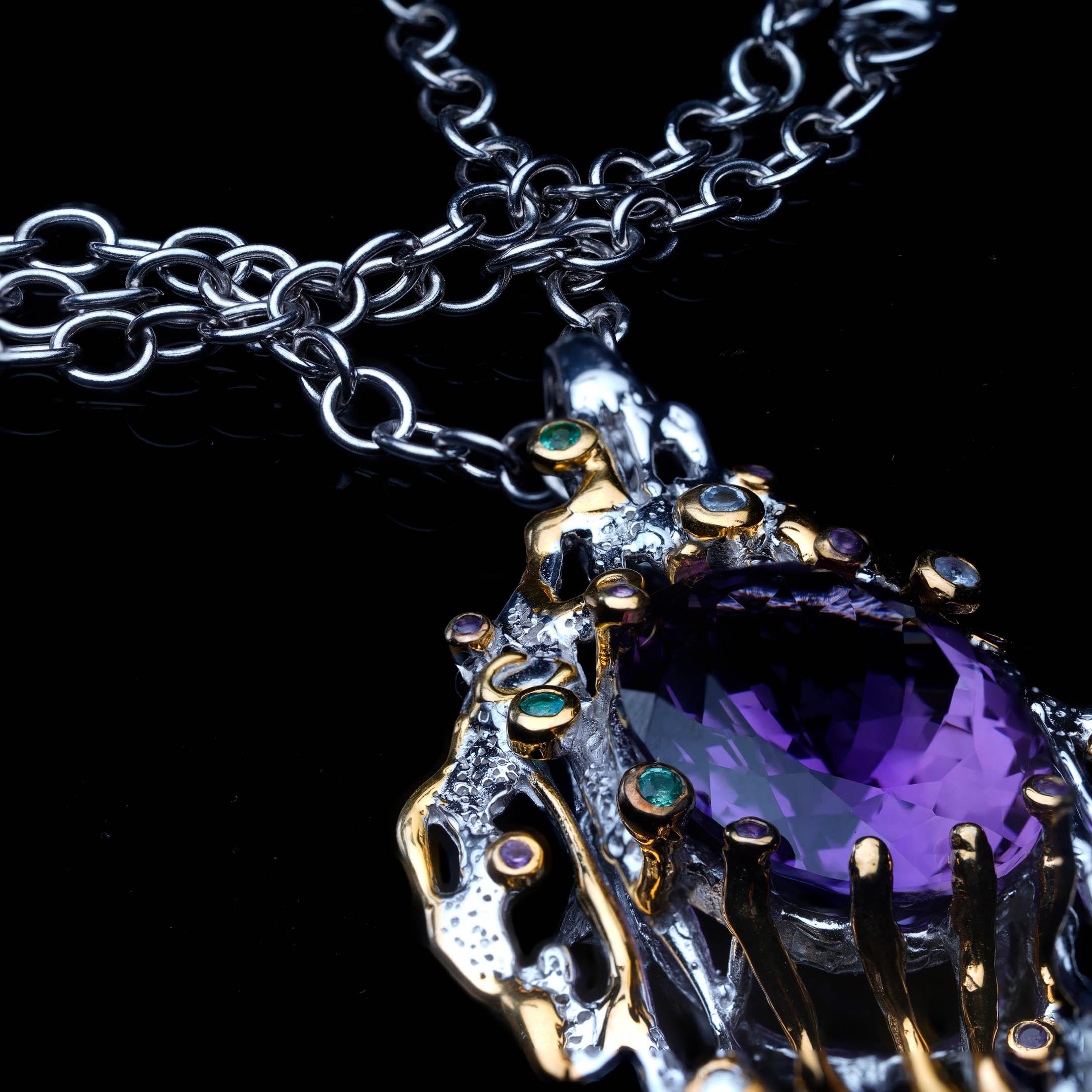 Ce pendentif extraordinaire est centré sur une améthyste naturelle de 27 carats : une pierre précieuse exquise d'un violet profond, taillée avec une clarté et une brillance superbes. La pièce maîtresse est encadrée par une monture ajourée en argent