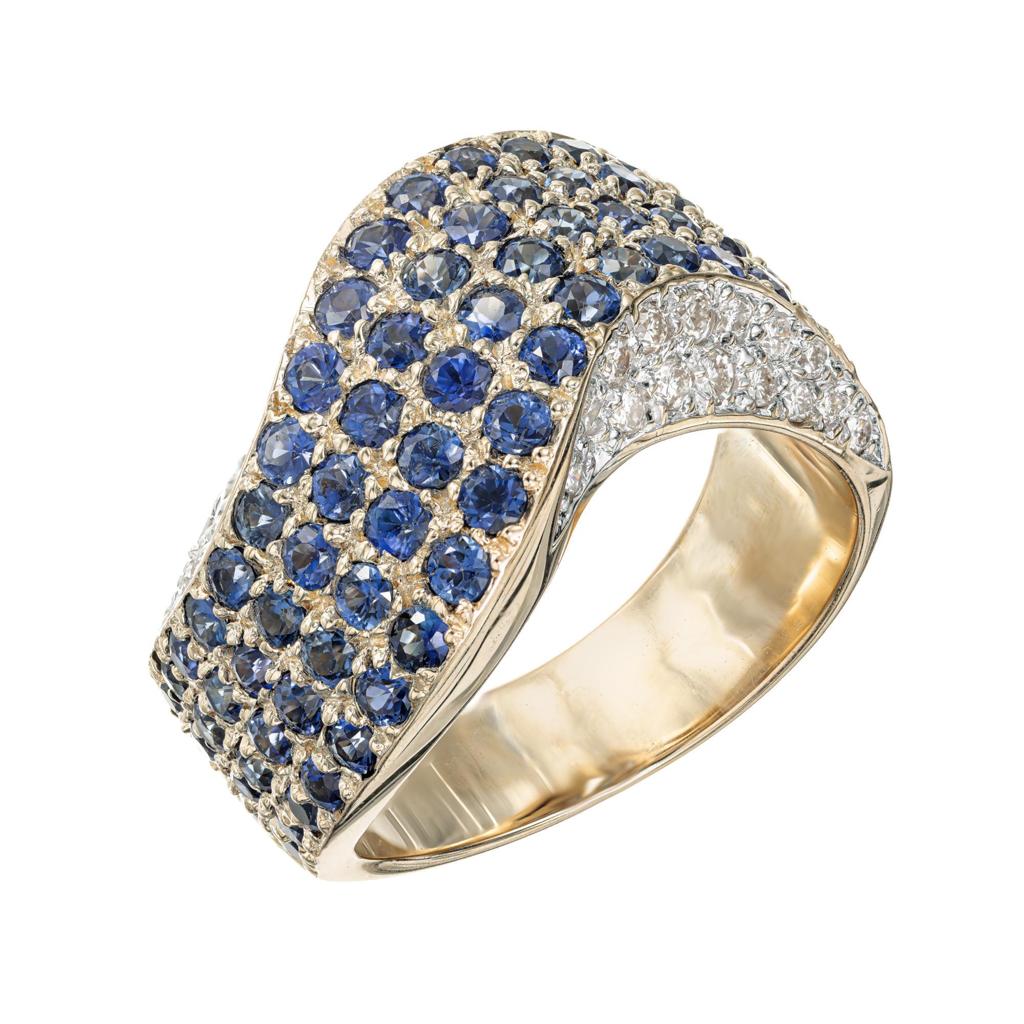 Sapphire and diamond swirl band ring. Slightly tapered domed swirl ring with a wave with 76 round sapphires and 36 round diamonds set in 14k yellow gold. The top is pave set with 4 rows of genuine bright sapphires. Each side is also pave set with 2