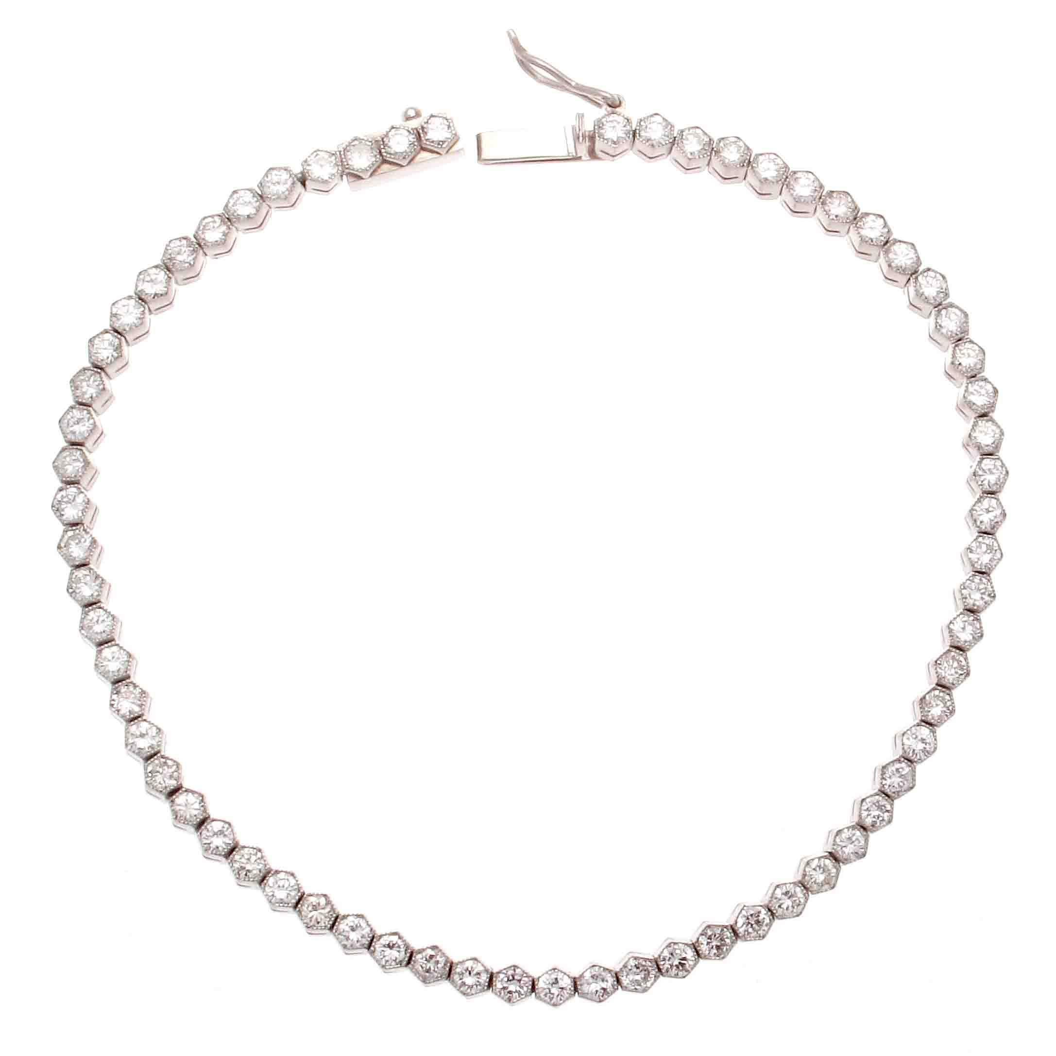 A tennis bracelet designed with numerous perfectly matching round brilliant cut diamonds each set in their own expertly crafted hexagon housing weighing a total of 2.70 carats that are F-G color, VS clarity. Hand crafted in platinum. 
