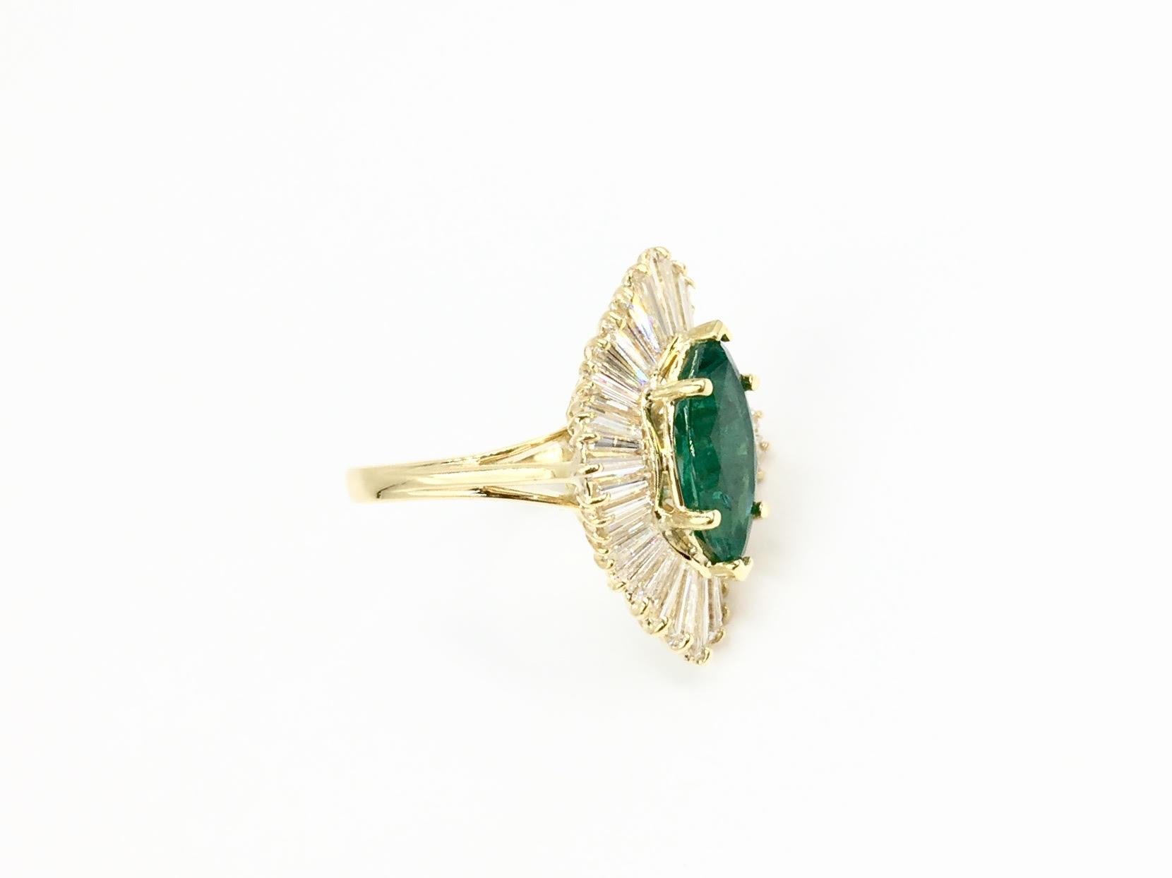 A classic vintage style 18 karat gold ballerina halo ring with generous amount of sparkle. This ballerina style ring features a very nice quality 2.70 carat marquise cut vivid emerald with medium transparency, excellent saturation and polish.
