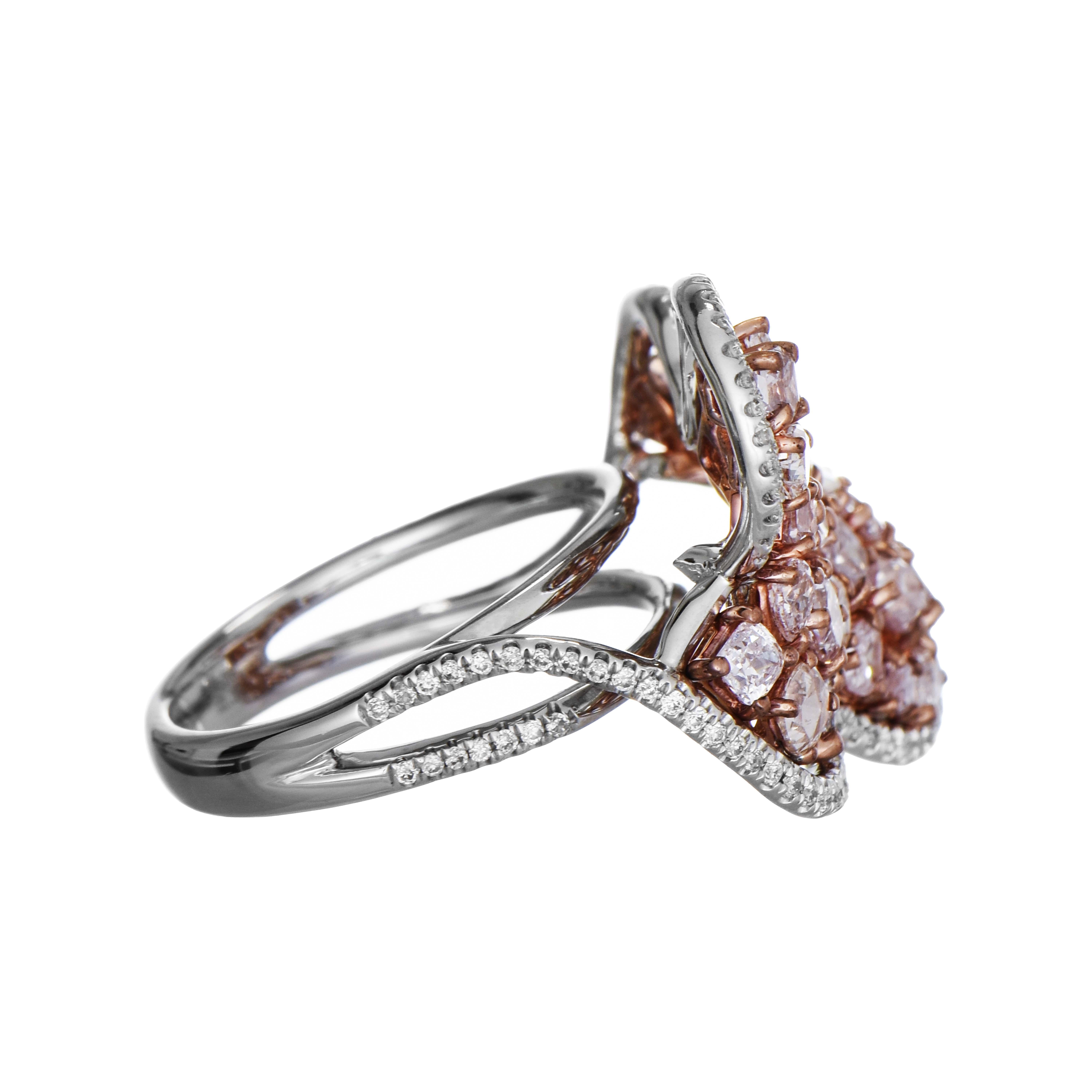 This lovely ring is inspired by the graceful form of a butterfly, featuring an arrangement of variously cut pink diamonds set in rose gold, outlined by a border of round white diamonds, all set in a white gold bypass shank embellished with round