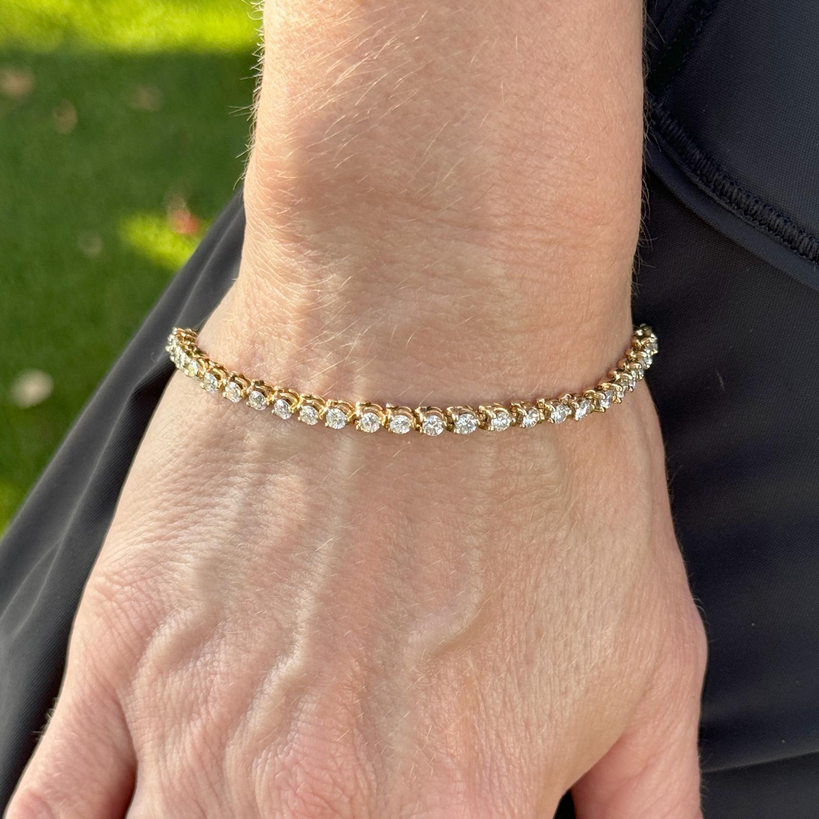 Diamond tennis bracelet fashioned in a 14 karat yellow gold setting. The 45 diamonds are round brilliant cuts, chosen for their exceptional sparkle and brilliance. The prong setting securely holds each diamond in place while allowing maximum light