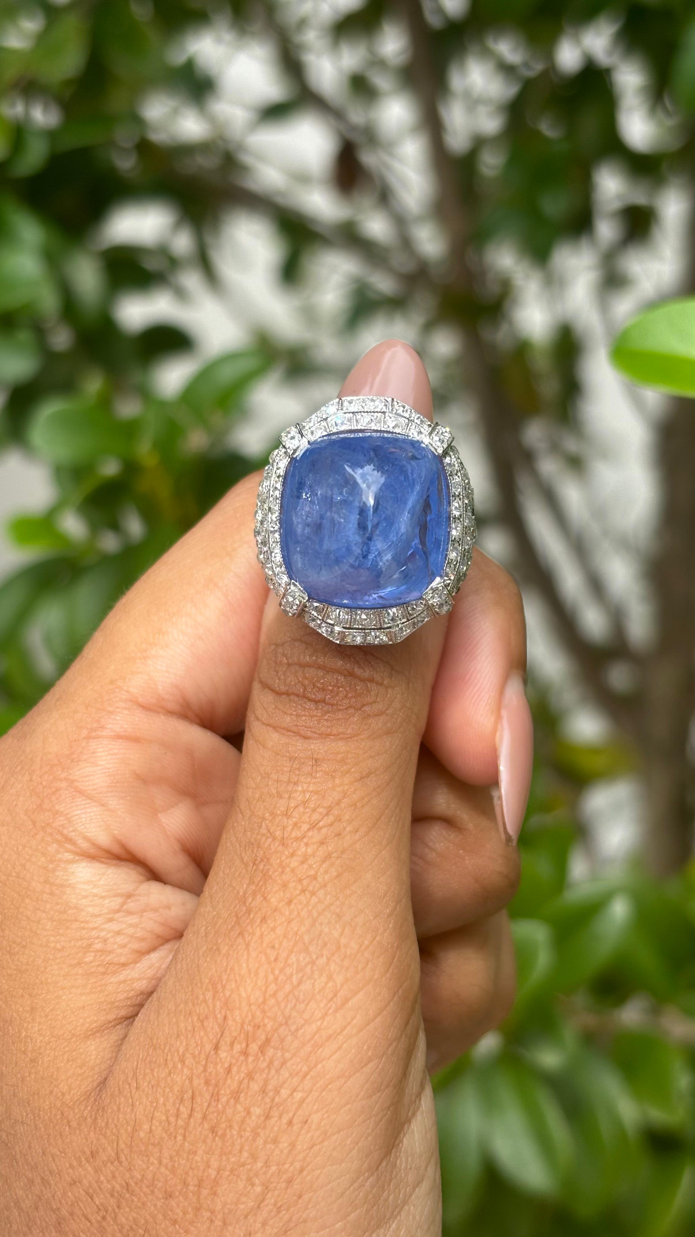 Lassen Sie sich von der fesselnden Anziehungskraft dieses Meisterwerks verzaubern, das Sie einlädt, in eine Welt von zeitloser Schönheit und Luxus einzutauchen. Sein Herzstück ist ein 27,05 Karat schwerer Sugarloaf Sapphire, ein Edelstein von