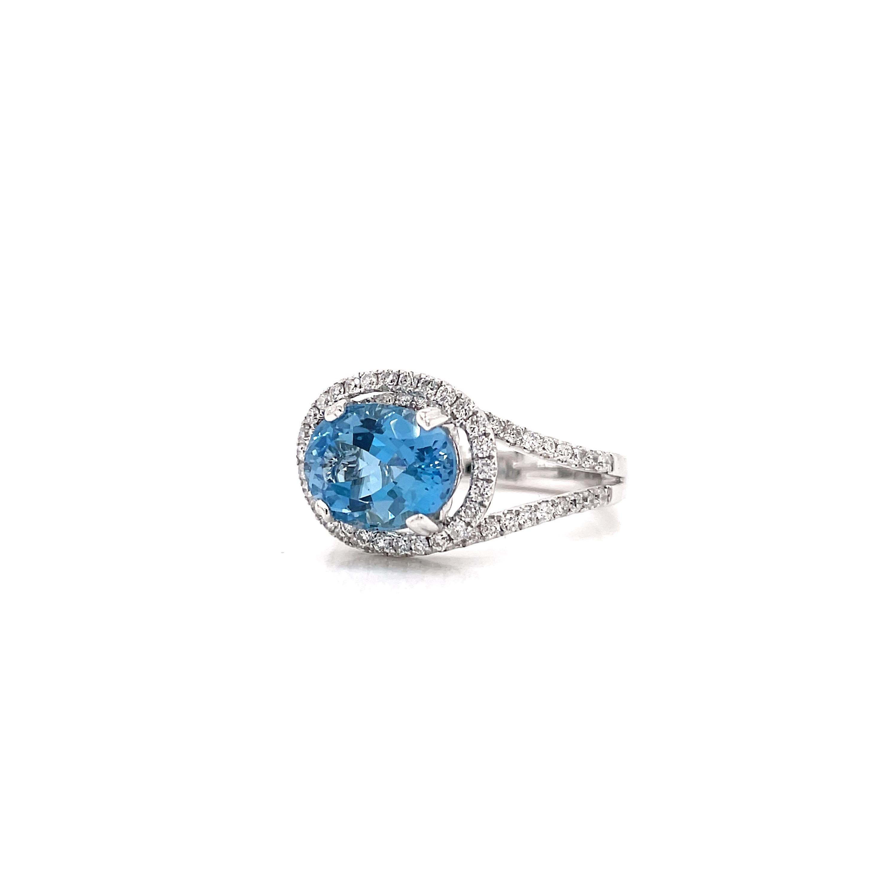 This gorgeous dress ring features a stunning oval aquamarine weighing 2.70ct mounted in a four claw, open back setting, The gemstone is beautifully encased in the centre of a diamond set swirled mount bringing the gemstones colour to life. The