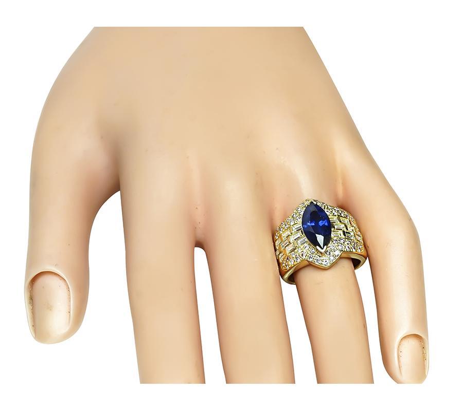 Dies ist ein wunderschöner Ring aus 18k Gelbgold. In der Mitte des Rings befindet sich ein schöner Saphir im Marquiseschliff mit einem Gewicht von ca. 2,70ct. Der Saphir wird von funkelnden Diamanten im Baguetteschliff und rosafarbenen Diamanten im