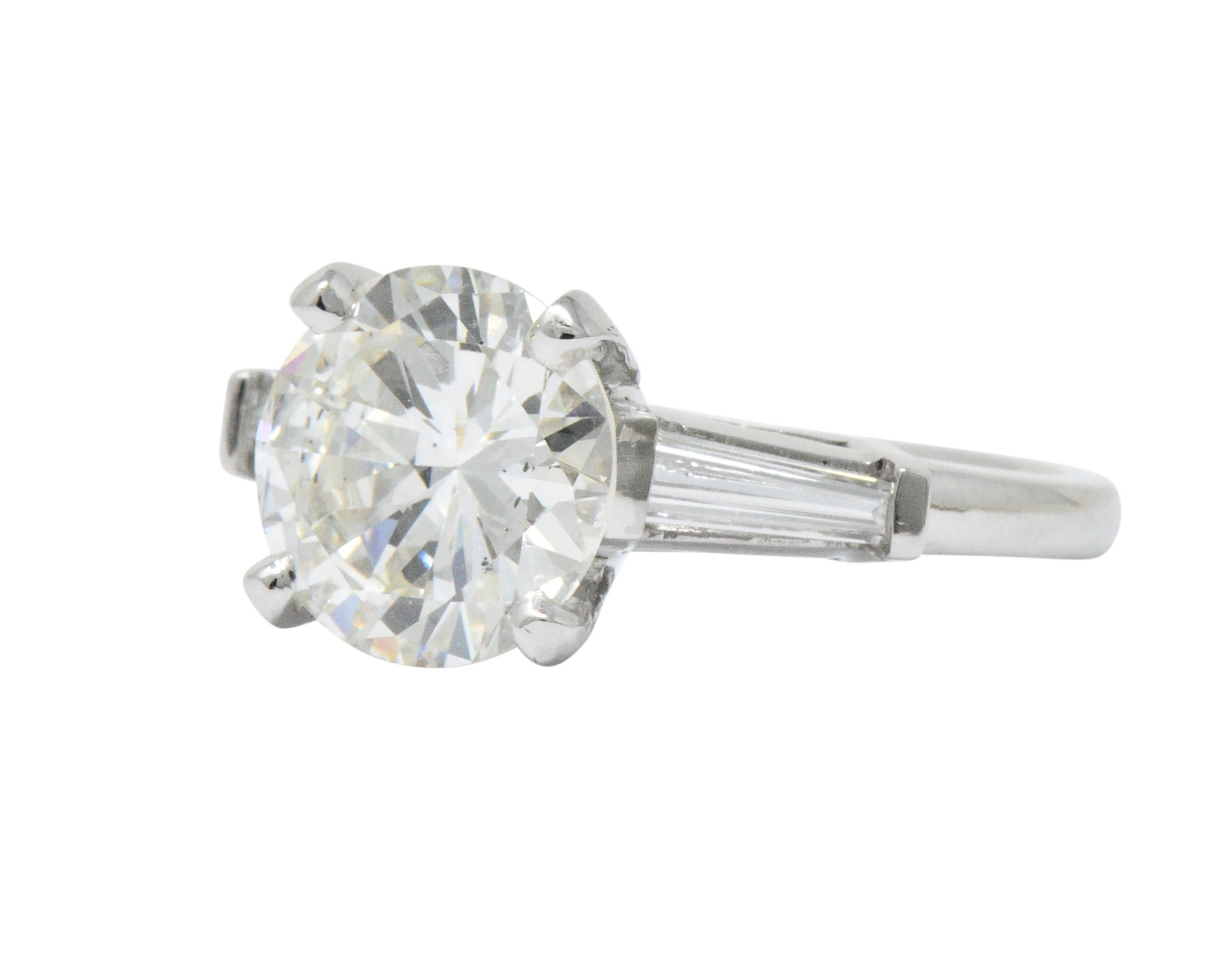 Centering a round brilliant cut diamond weighing 2.36 carats, J color and SI2 clarity

Flanked by tapered baguette cut diamonds, weighing approximately 0.35 carat total, G/H color and VS clarity

Classic cathedral style setting

Ring Size: 5 &