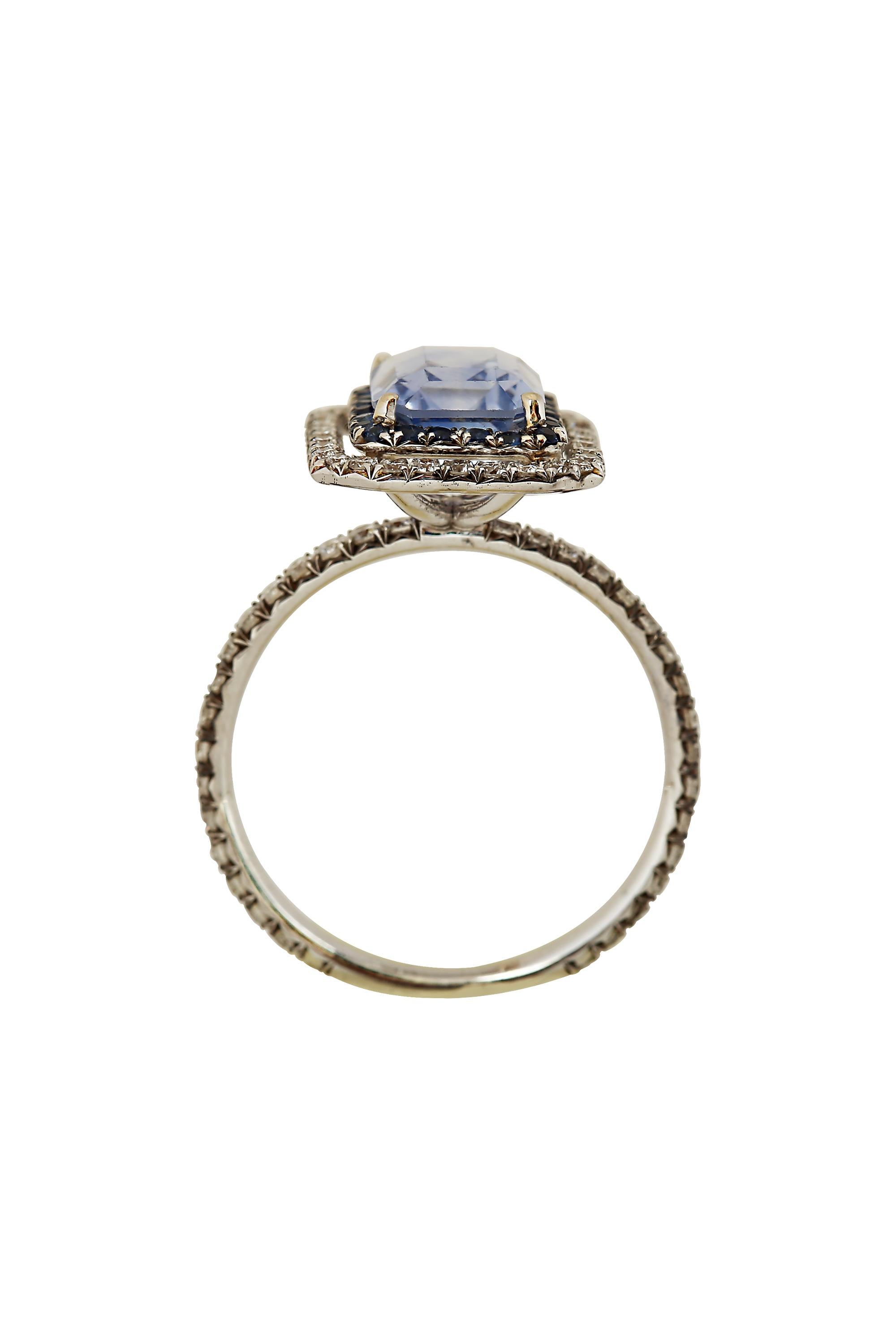 Designed and created by Gems Are Forever, Inc. Beverly Hills, this limpid light blue rectangular sapphire, weighing 2.71 carats, is smartly set off by a double framing of lively blue sapphires and diamonds creating a polished and classic ring.