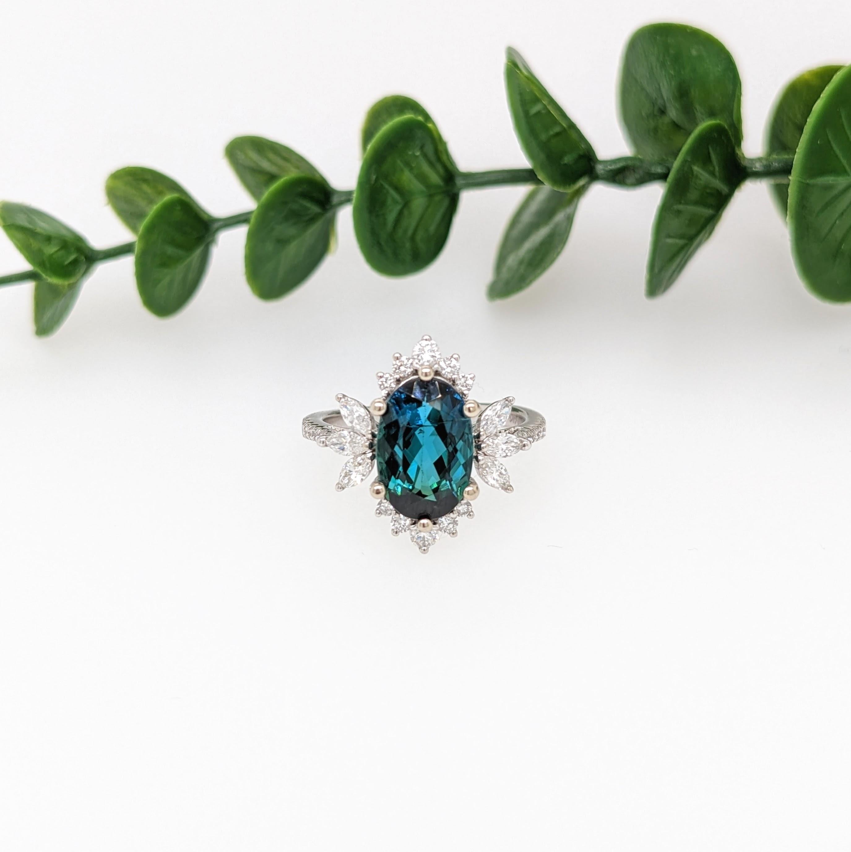 This gorgeous blue tourmaline ring is showcased in a custom NNJ ring design with sparkling round and marquise natural diamond accents that give an extra sparkle! With radiant diamonds surrounding an 11x7mm tourmaline, this piece is classy and