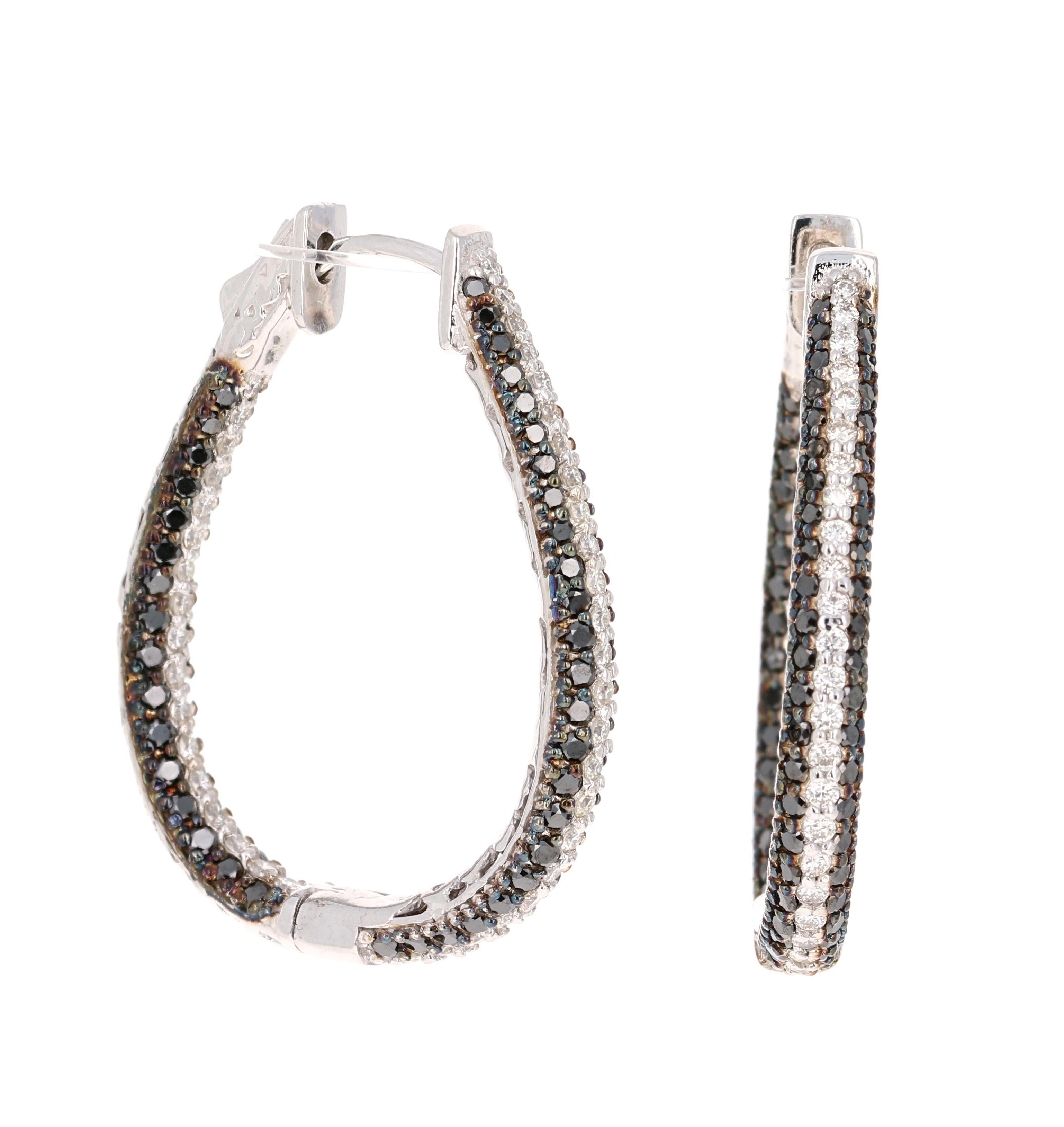 These earrings have Round Cut Black Diamonds that weigh 1.82 Carats and Round Cut White Diamonds that weigh 0.90 Carats. The total carat weight of the earrings are 2.72 Carats. 
Curated in 14 Karat White Gold they weigh approximately 10.3 grams

The