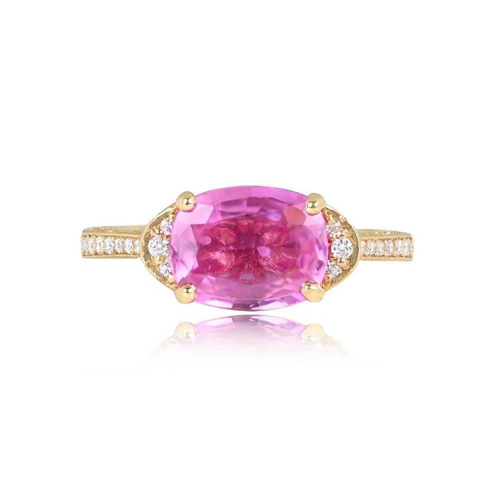 An elegant 18k yellow gold ring showcases a prong-set 2.72-carat oval-cut natural pink sapphire. The shoulders are adorned with 0.10 carats of pave-set round brilliant cut diamonds, complemented by an additional 0.10 carats of diamonds on the