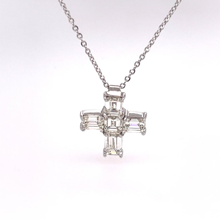 Diamond cross necklace featuring  5 emerald cut diamonds with a total carat weight of 2.72.  The cross pendant is set in 18k white gold and the chain is in 14k white gold. 