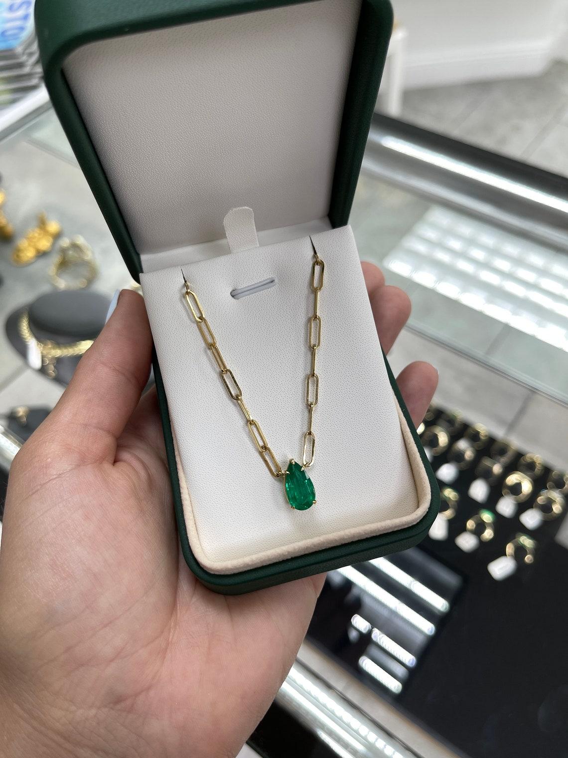 Se muestra un impresionante collar solitario de esmeralda engastado en oro amarillo de 18 quilates. Este magnífico anillo solitario lleva una esmeralda entera de 2.73 quilates en un engaste de cuatro garras. Totalmente facetada, esta gema muestra un