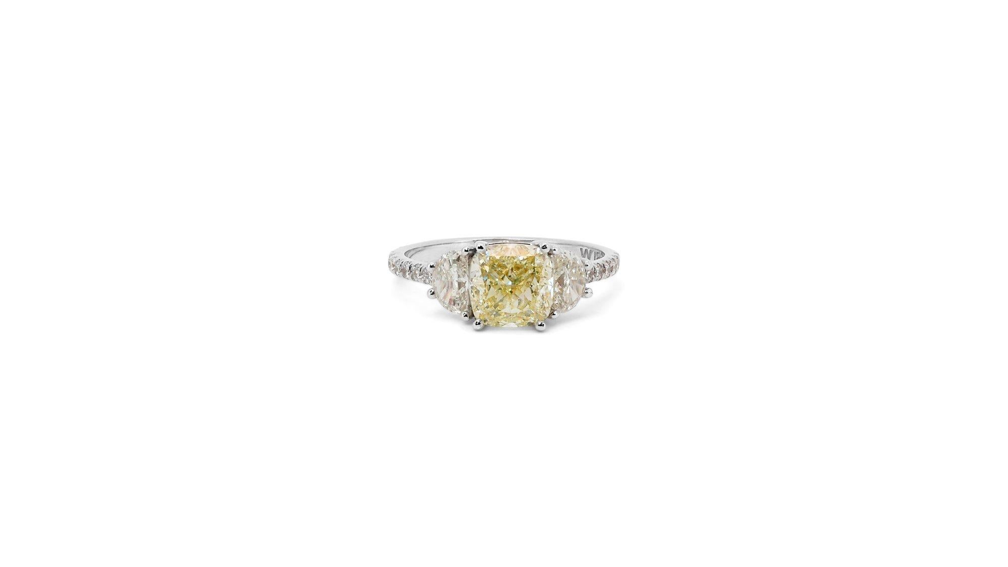 Ein eleganter Ring mit einem 2,01-karätigen, quadratischen, kissenförmig modifizierten Naturdiamanten. Er hat 0.6 Karat seitliche Diamanten, die seine Eleganz noch unterstreichen. Das Schmuckstück ist aus 18 Karat Weißgold mit einer hochwertigen