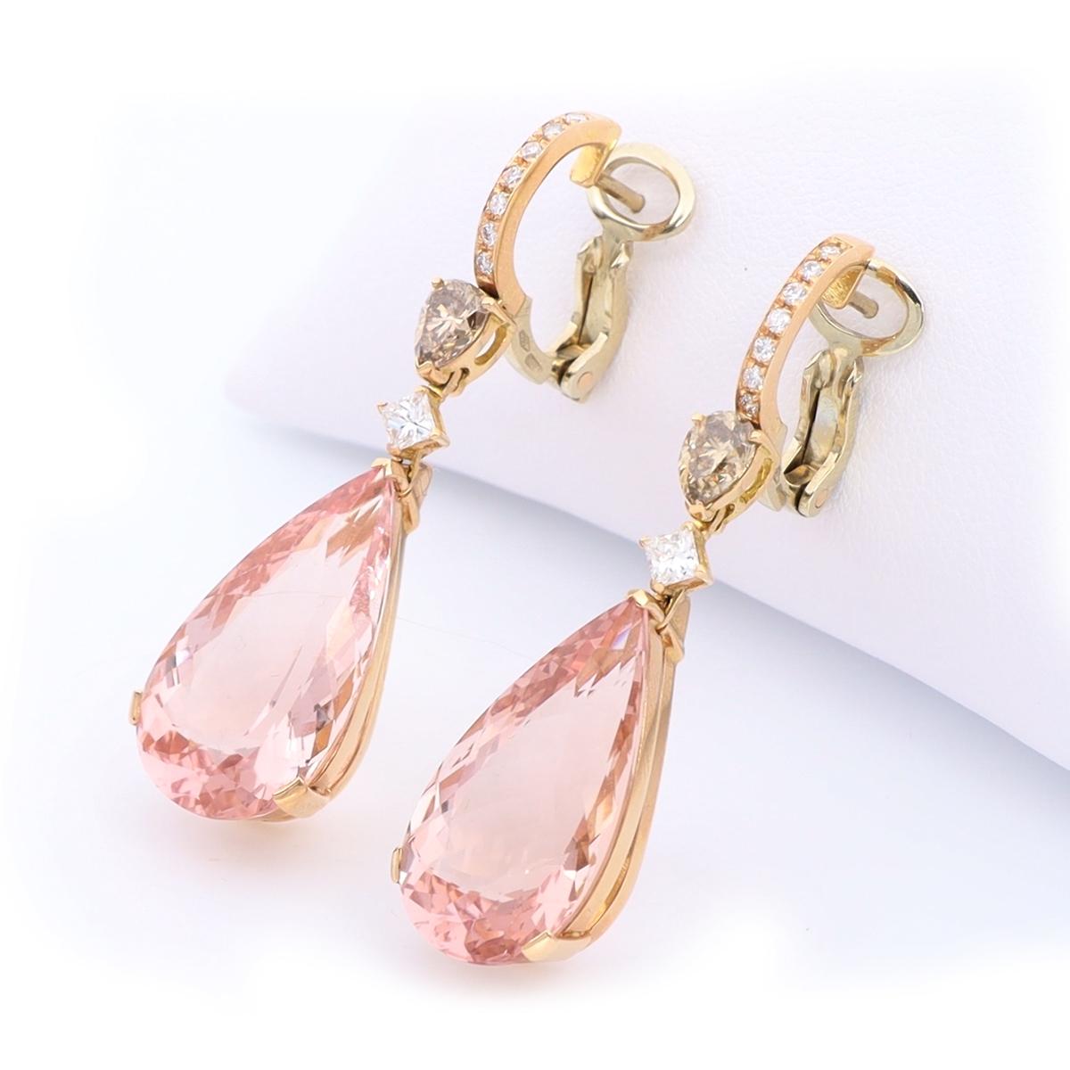 These delicate and feminine drop earrings feature a gorgeous pear-shaped 27.35 ct pink morganite stone suspended from white and brown diamonds. Morganite, the birthstone of June, is said to represent divine love and to gently purify the heart and