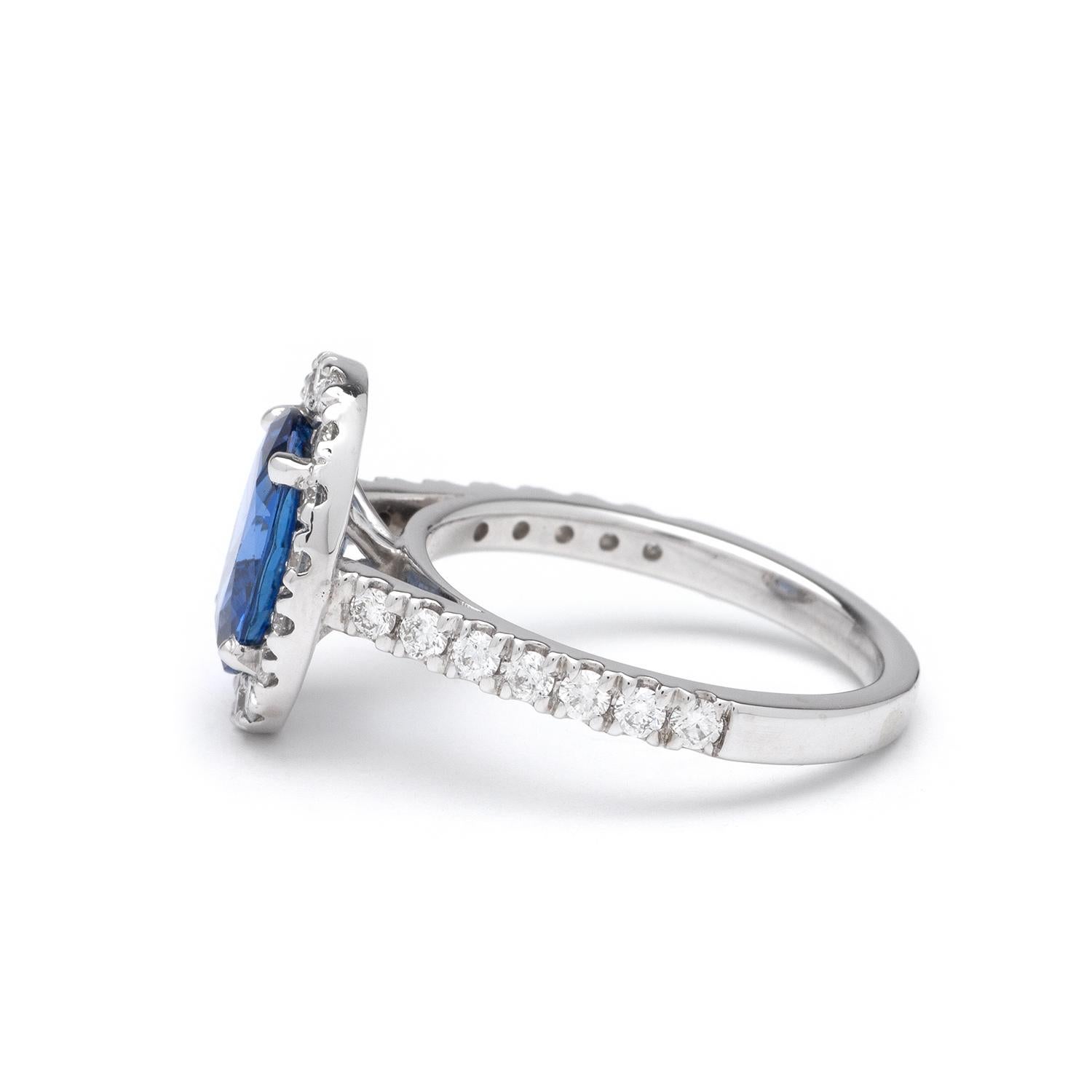 This ring features a halo design of G color, SI1 clarity, and 0.72ct Round side diamonds set in 14K white gold. The center gemstone is a 2.73ct Oval blue sapphire measuring 10.29 x 7.72mm. Finger size 6 1/2.