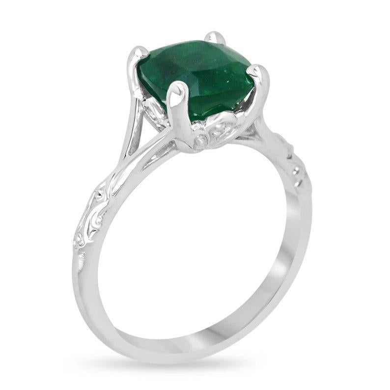 Celebrate your love with the exquisite elegance of our solitaire emerald engagement ring. Featuring a magnificent 2.73-carat cushion-cut Zambian emerald of exceptional quality, its rich dark green hue and semi-transparent clarity exude timeless