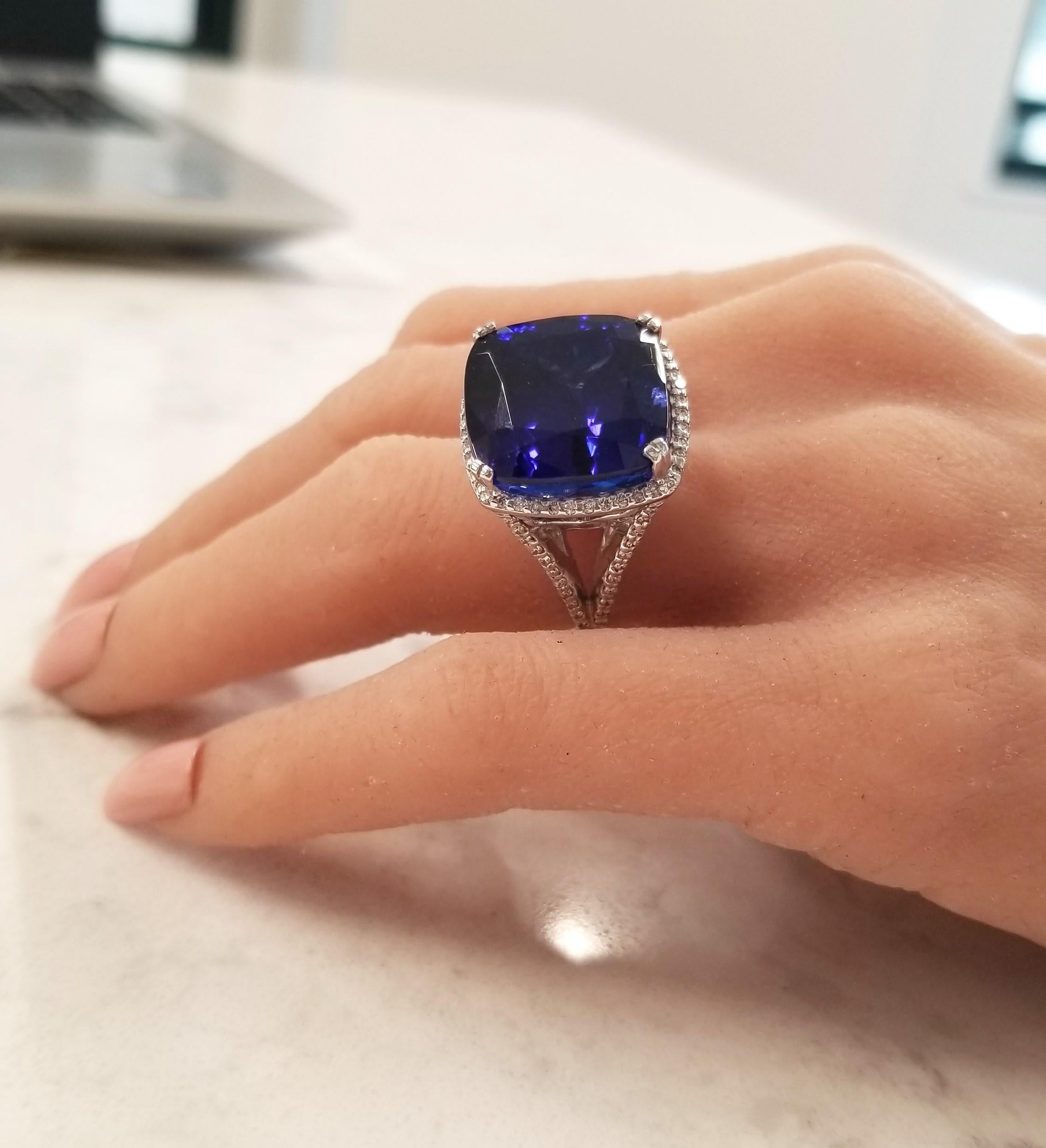 Catch every eye when you enter a room wearing this spectacular ring! No one will be able to resist being captivated by the gorgeous and bold 27.4 carat – 16.87 x 16.82 millimeter tanzanite center. This gem is big, it's bold, and it's rare. The color