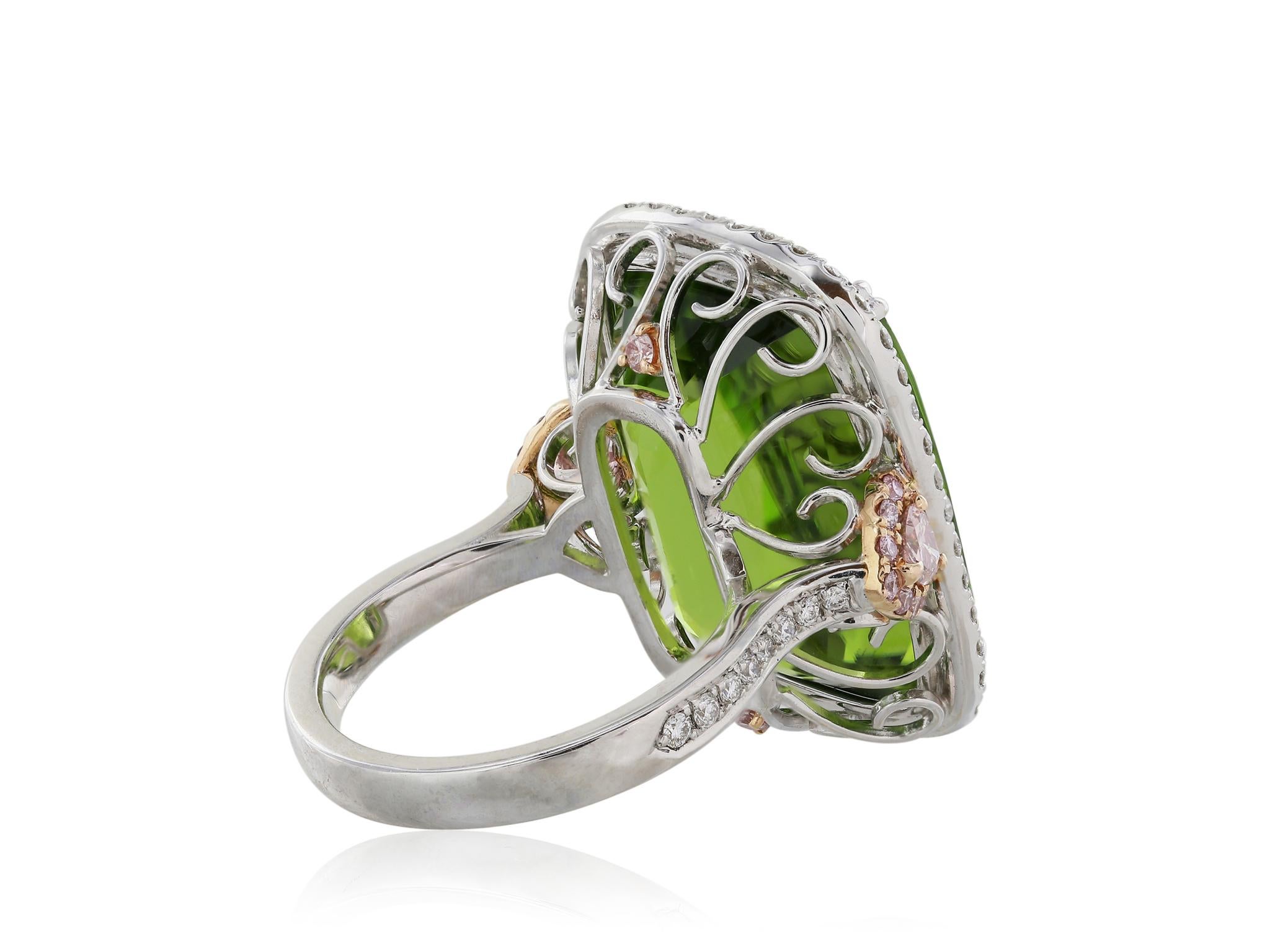 18 Karat pink and white gold ring featuring one natural 27.43 carat cushion cut Peridot C. Dunaigre certified. The Russian Peridot is surrounded by a halo of round brilliant cut white diamonds and flanked by two heart shaped fancy pink diamonds.