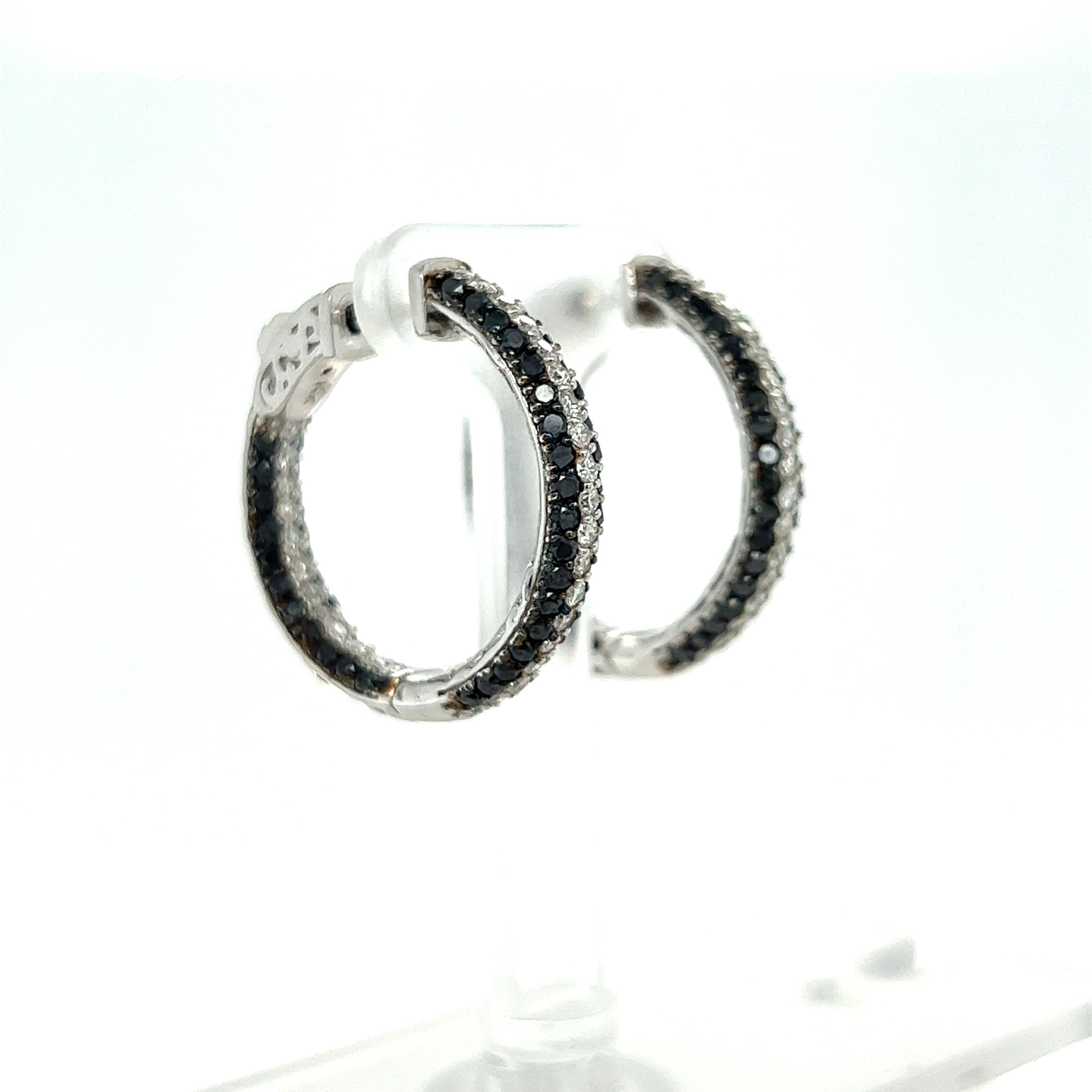 These hoop earrings have Round Cut Black Diamonds that weigh 1.89 Carats and Round Cut White Diamonds that weigh 0.86 Carats. The total carat weight of the earrings are 2.75 Carats. 

Curated in 14 Karat White Gold they weigh approximately 8.9