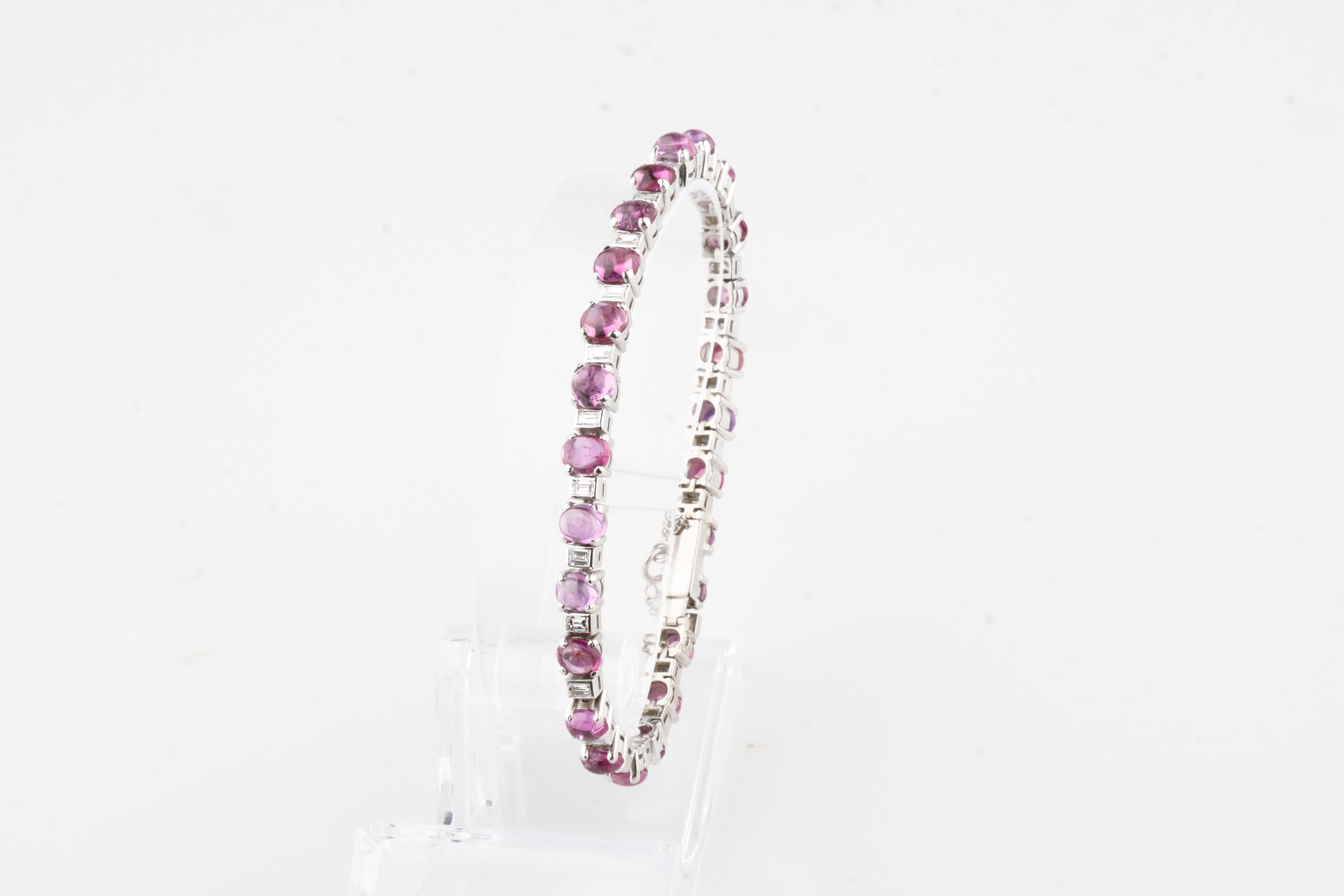 Wunderschönes Platinarmband mit abwechselnden Rubin-Cabochons in Zackenfassung und Diamanten im Prinzessinnenschliff in Lünettenfassung
Cabochon-Rubine variieren in Farbe und Form, haben aber im Durchschnitt ein schönes Rosarot.
Inklusive
