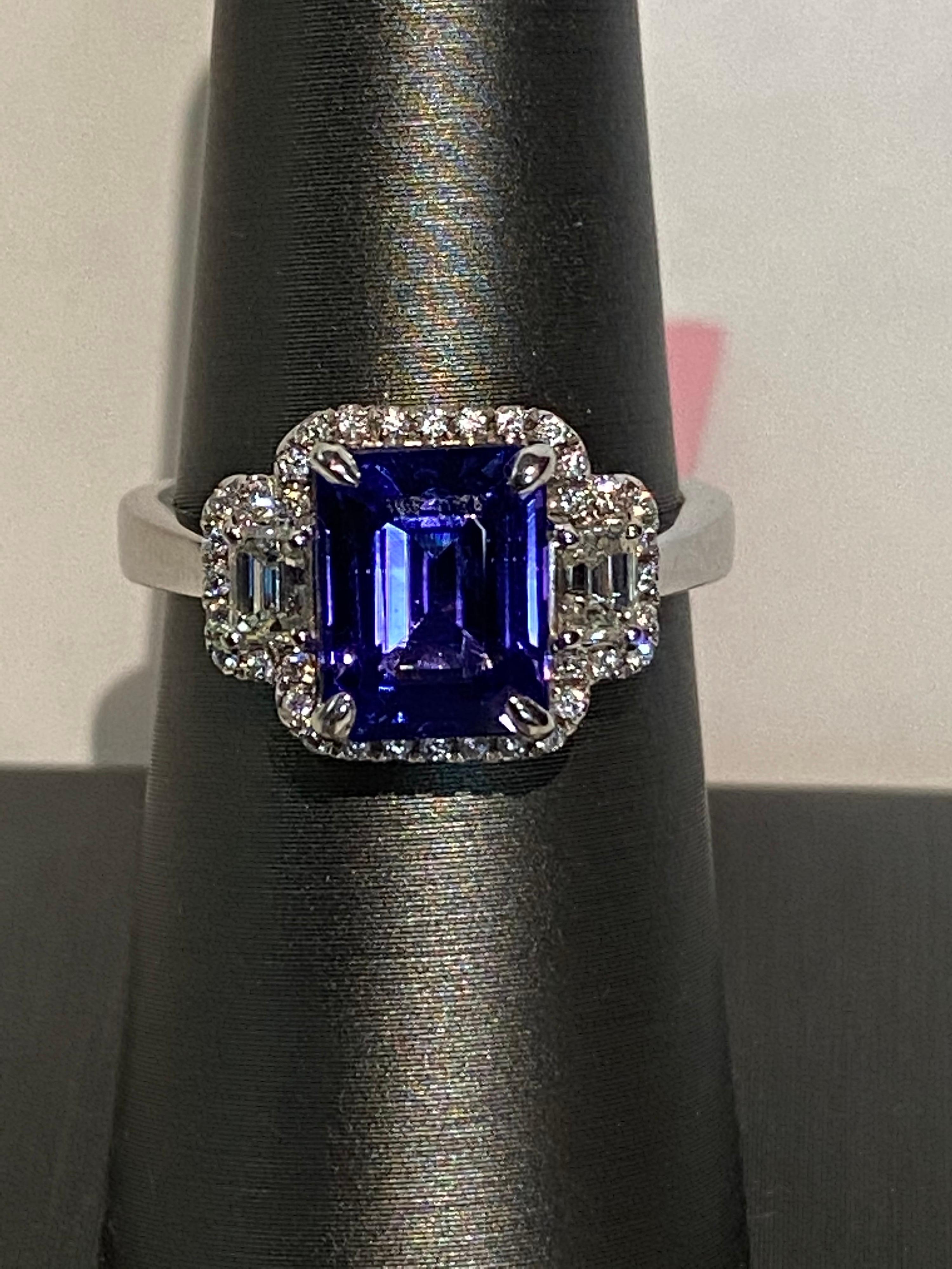 This emerald cut tanzanite has two baguette diamonds on each side and a halo of round diamonds. Mounted with hand, this beautiful ring is set in white gold. Tanzanite has a super lustre and color.
Tanzanite: 2.75ct
Diamond: 0.50ct
White Gold: