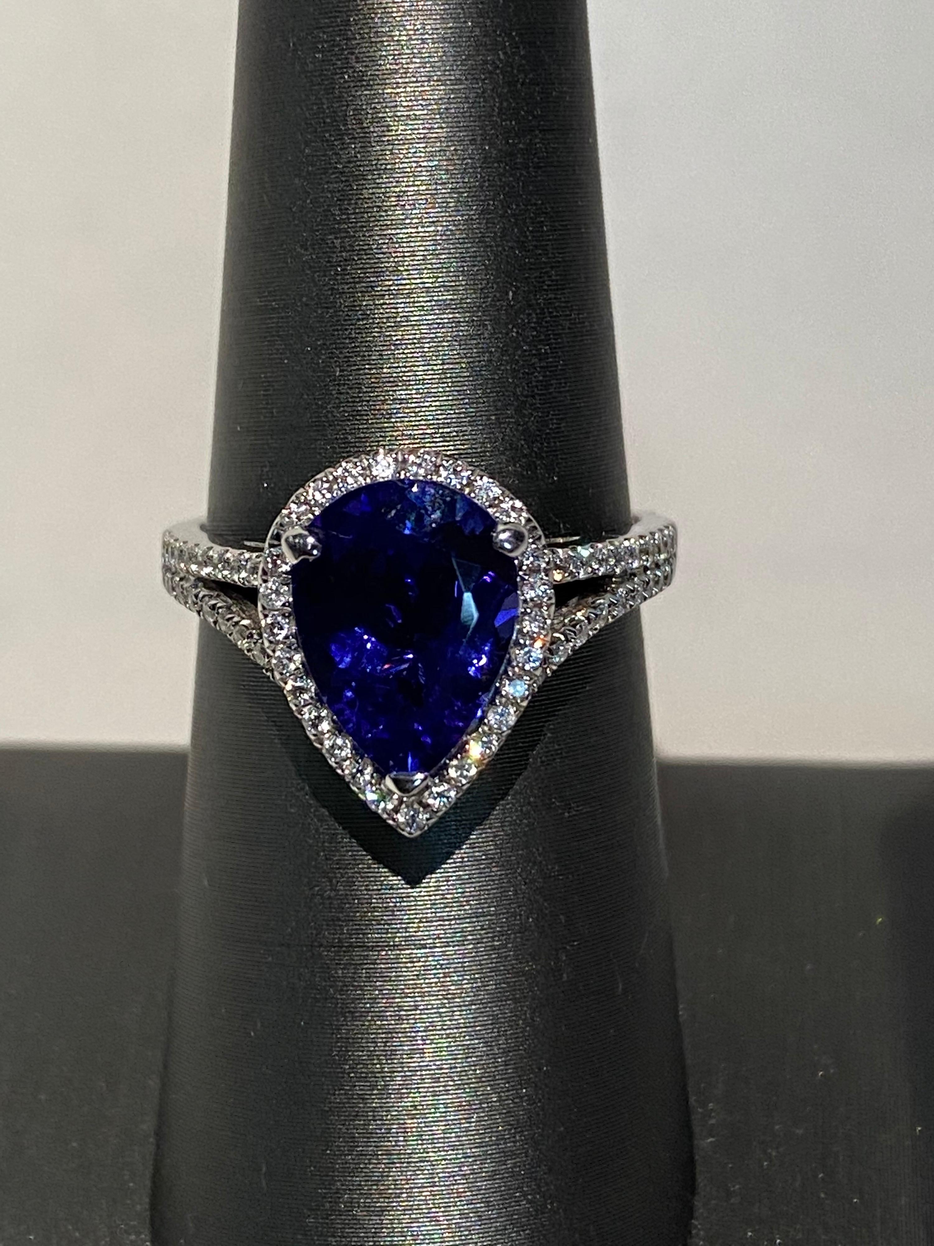 A pear shaped tanzanite is set in prongs and framed by a diamond halo. Band has two rows of diamond. Set in white gold and handcrafted. Diamond accents give the tanzanite ring an elegant stunning look. 
Tanzanite: 2.75ct
Diamond: 0.25ct
Gold: