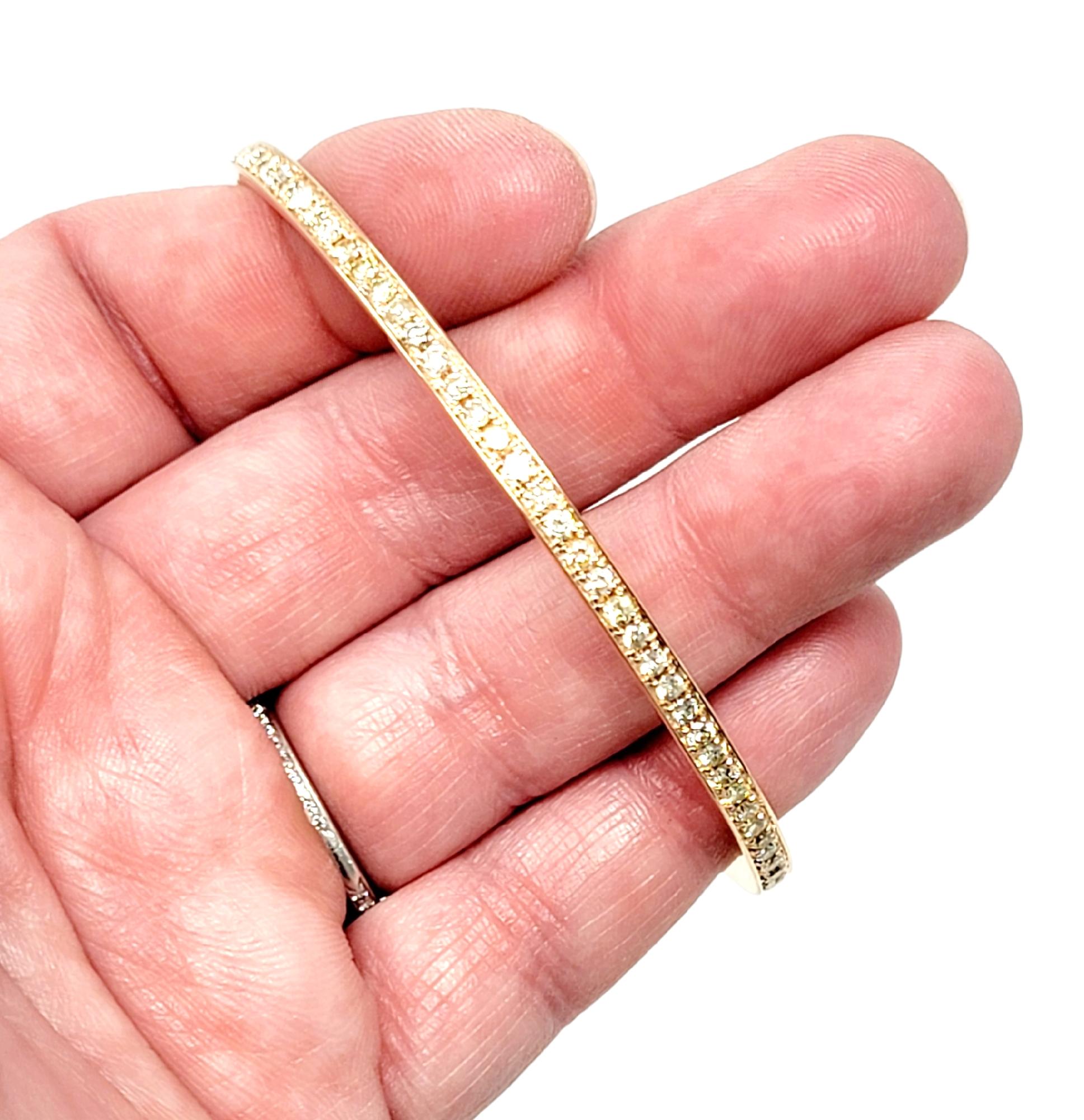 Simple yet stunning diamond eternity bracelet. This delicate paved bangle bracelet boasts an ultra feminine feel, while the sleek simplicity gives it a modern elegance. It features 91 natural round brilliant diamonds, near colorless to light yellow