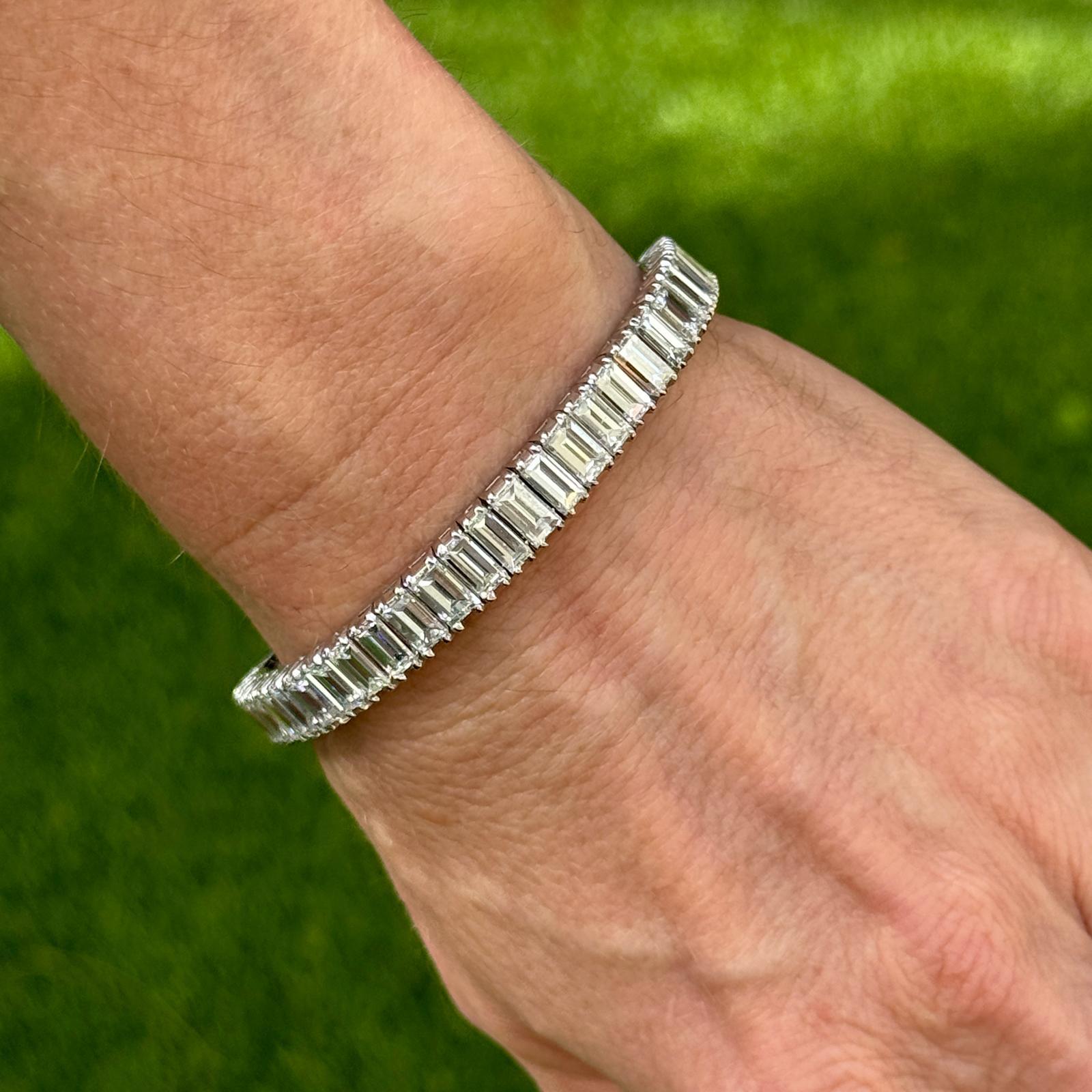 Stunning baguette cut diamond line bracelet handcrafted in platinum. The bracelet features 50 emerald cut high quality diamonds weighing approximately 27.5 carat total weight. The diamonds are graded F-G color and VS clarity. The bracelet measures 7