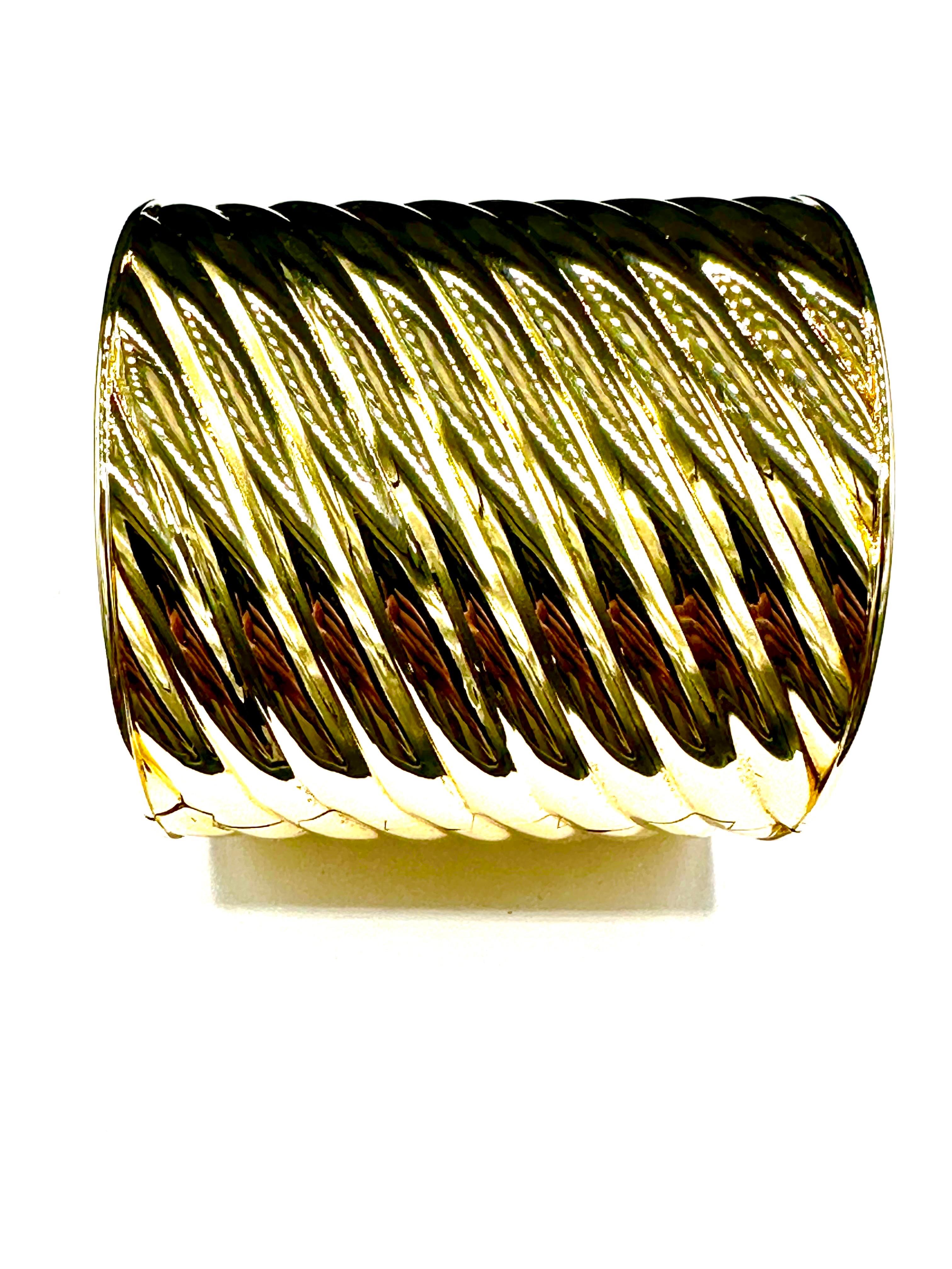 This is an amazing cuff bracelet!  This cuff is made in 18K yellow polished ribbed pattern gold.  It is 2.75 inches at the top, tapering to 2.10 inches at the bottom.  The bracelet is spring hinged on both sides for ease of slipping on.  This will