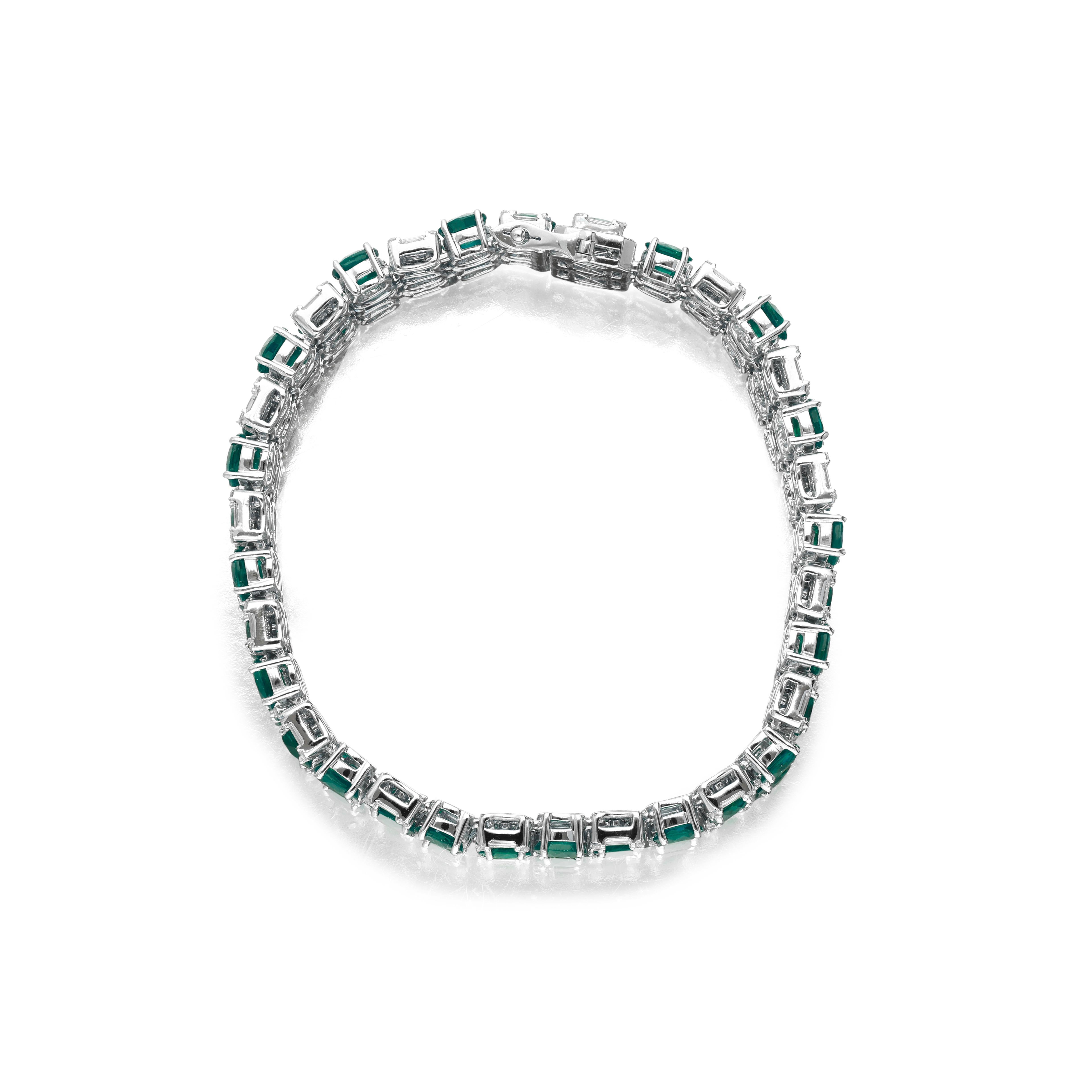 stunning and intricate piece of jewelry that showcases a luxurious blend of emeralds and diamonds. This exquisite item is set with 50 vibrant emeralds, totaling approximately 21 carats, creating a captivating green hue that beautifully contrasts