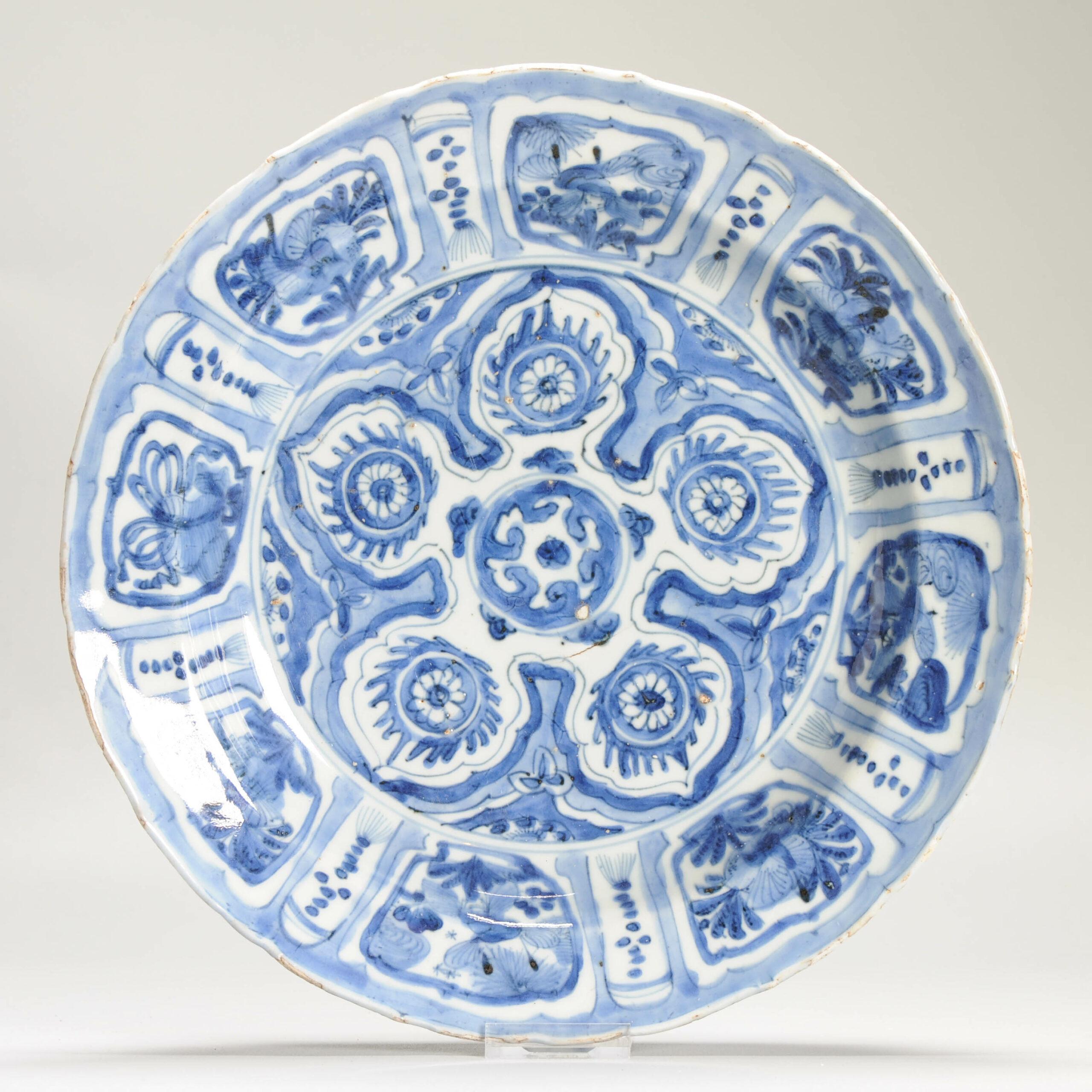 Large late Ming dynasty Wanli period blue and white kraak ware export porcelain deep charger. The centre medaillon is unusually painted with 5 cakras around a flaming scroll forming a five-patelled motif resembling a large flaming wheel. This