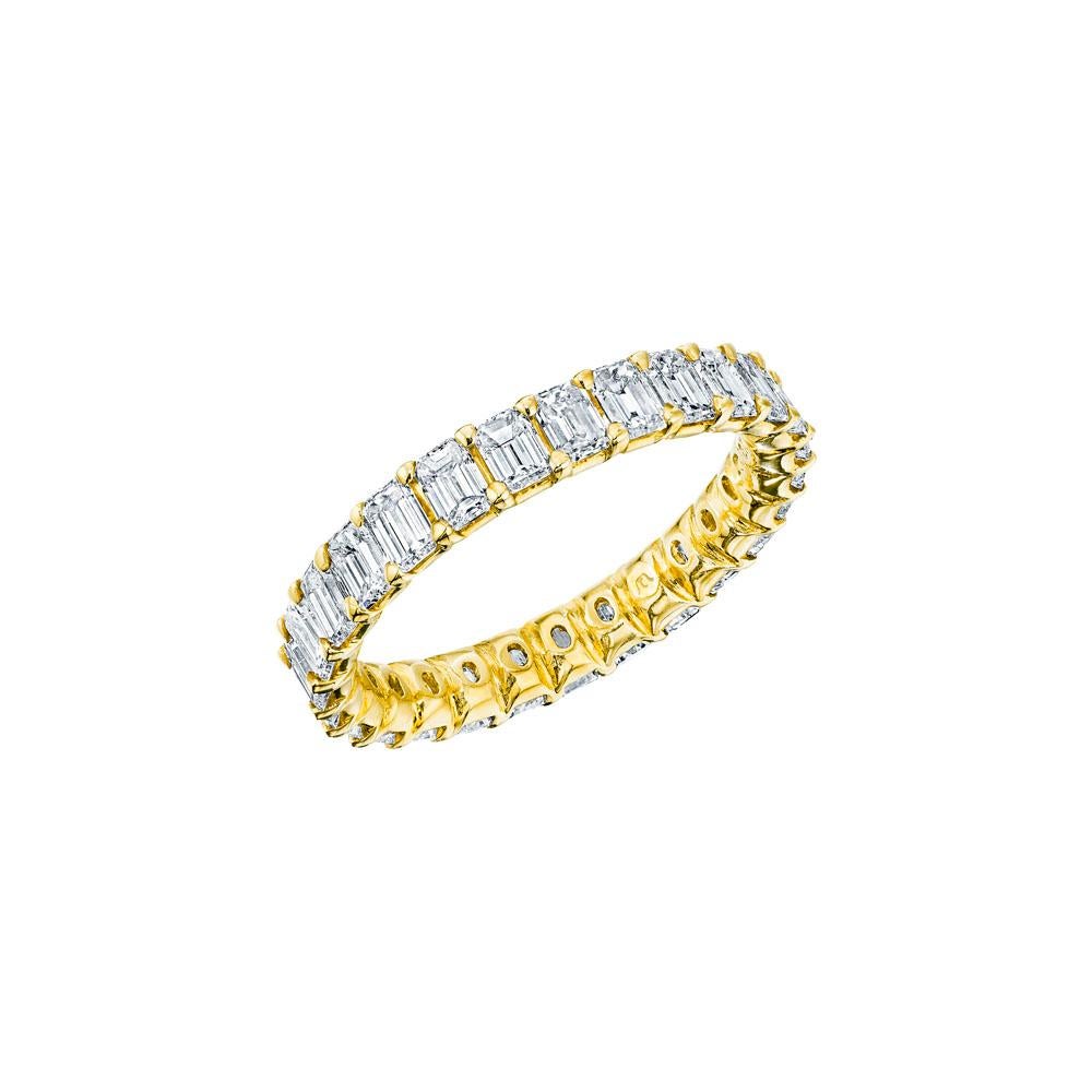 • Crafted in 18KT gold, this eternity band is made with 27 emerald cut diamonds which encircle the finger and has a combining total weight of approximately 2.75 carats. The stones are set into a shared prong basket setting. Worn beautifully on its