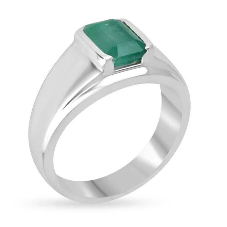 This bold men's solitaire ring features a stunning emerald-cut Zambian emerald, showcasing a captivating medium dark green color. Set vertically in a sleek half bezel, the emerald’s striking beauty is complemented by the modern design. Crafted in