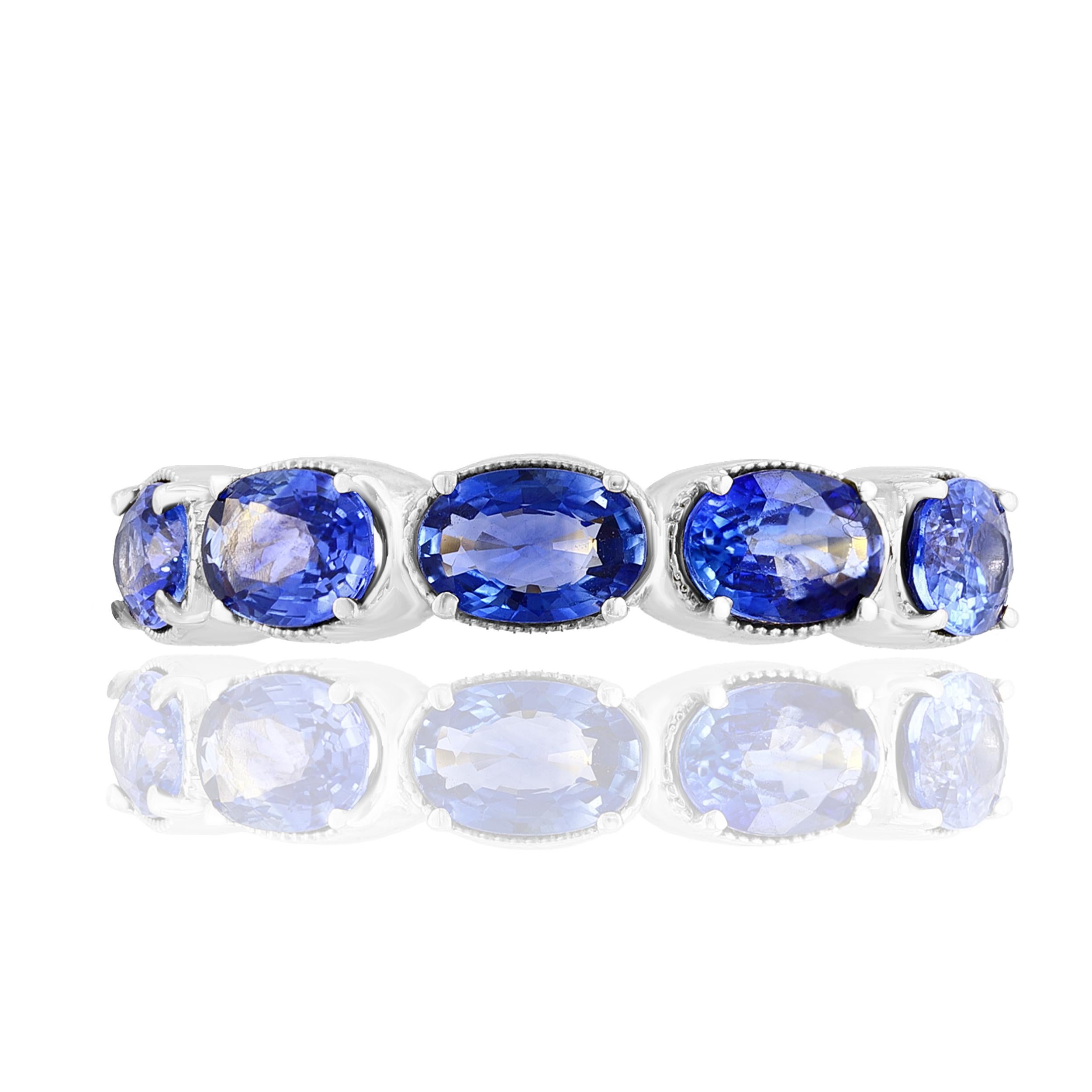 A fashionable and classic wedding band showcasing 5 color-rich blue sapphires weighing 2.76 carats total. Stones secured with a 4 prong setting made with 14 karats white gold. A versatile piece that can be worn as a fashionable right-hand ring as
