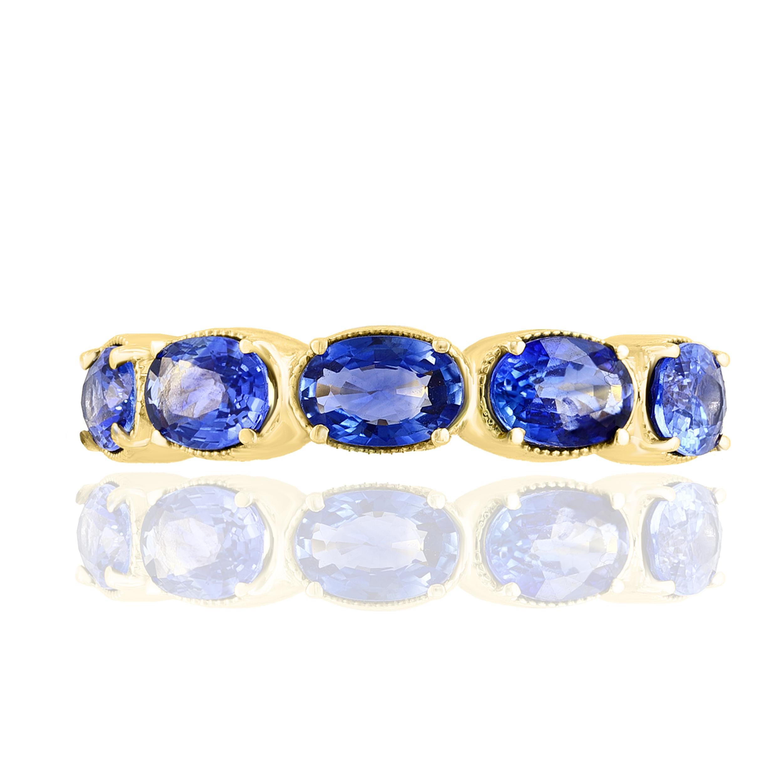 A fashionable and classic wedding band showcasing 5 color-rich blue sapphires weighing 2.76 carats total. Stones secured with a 4 prong setting made with 14 karats yellow gold. A versatile piece that can be worn as a fashionable right-hand ring as