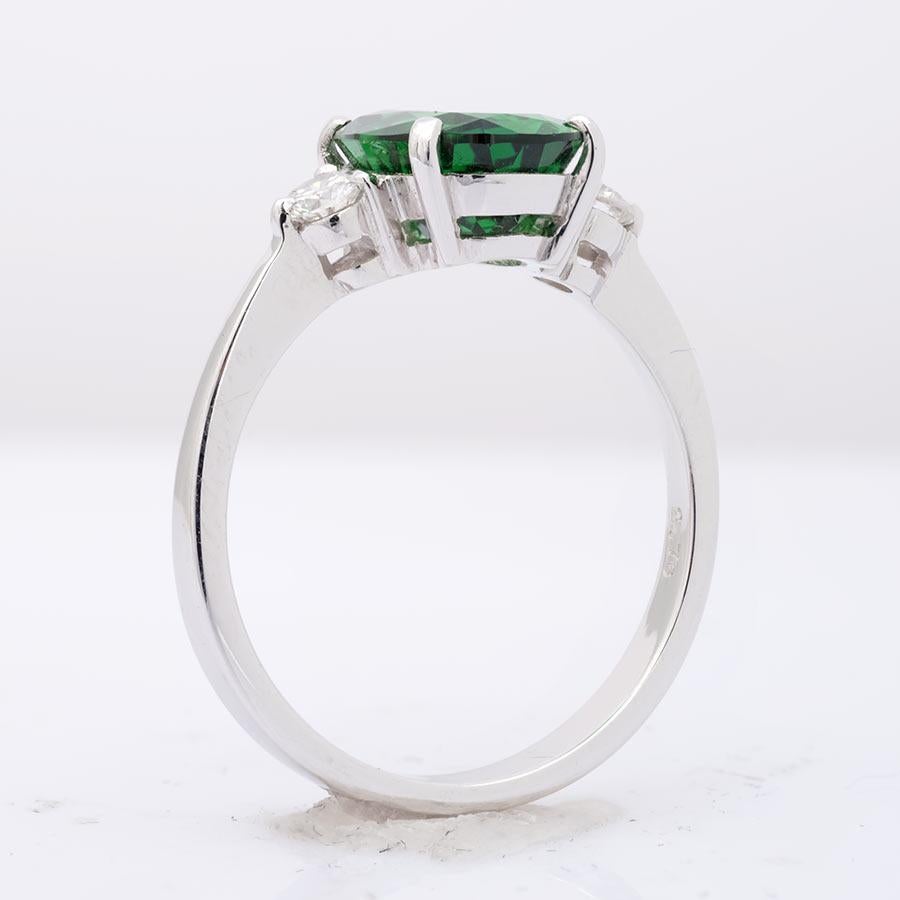Natural and untreated this Tsavorite Garnet cut as an oval is a stunning choice. Held in place by prongs this vibrant green garnet appears to almost float on the finger. Supported by glittery diamonds this ring is just what she needs if she likes