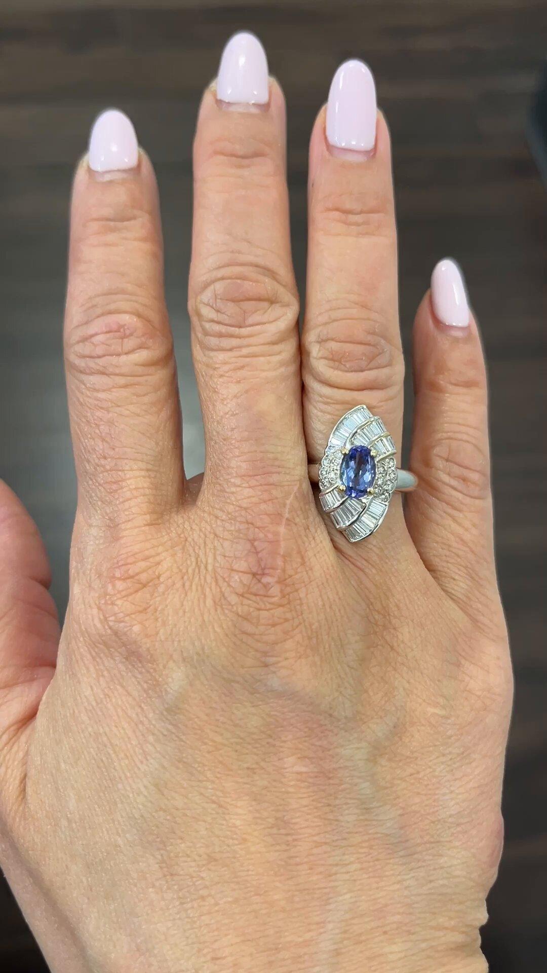 Get ready to dazzle onlookers with this stunning 18k white gold ring. The ring features a beautiful blue tanzanite stone as the main attraction, with a total carat weight of 2.76. The gemstone is further accented by sparkling diamonds, making it a