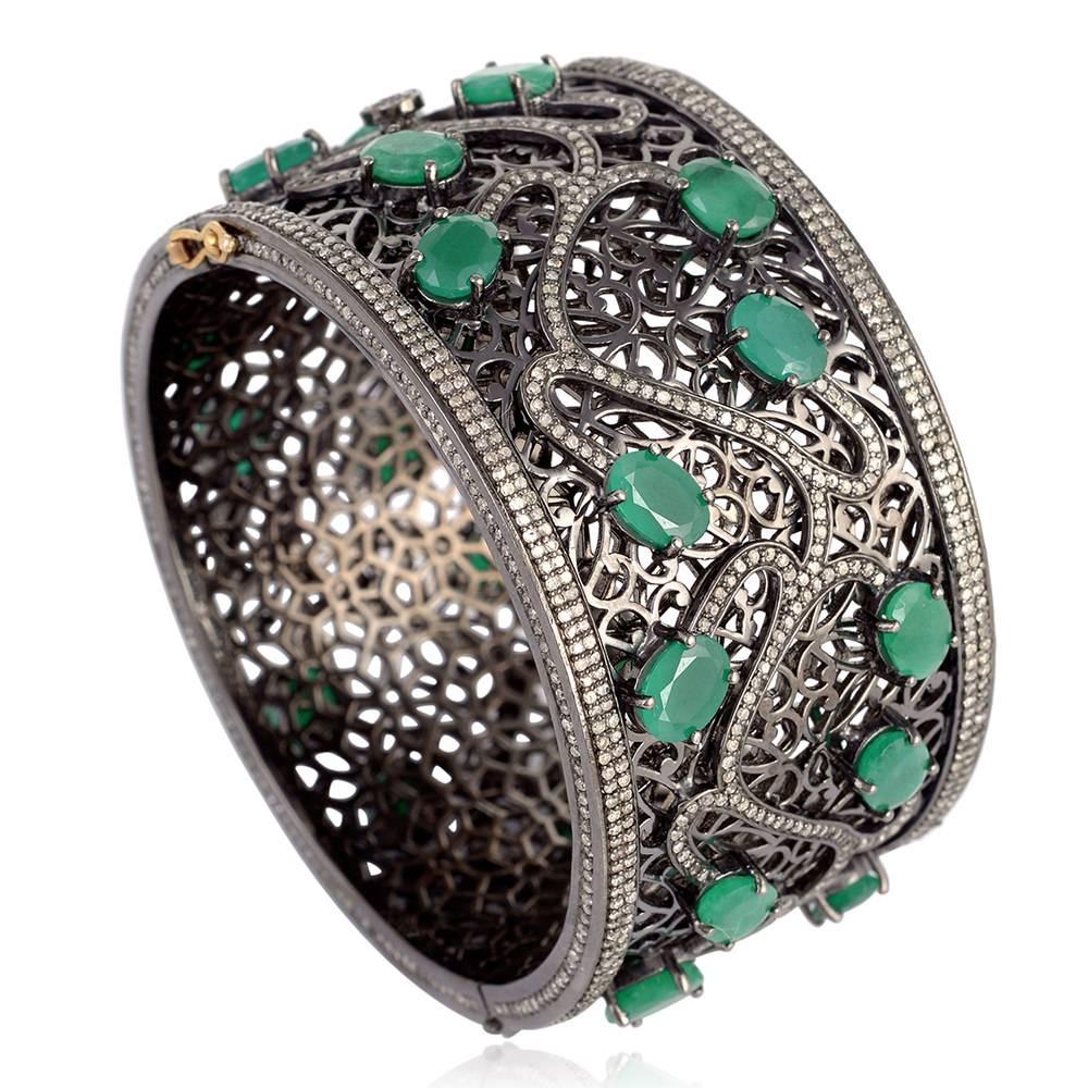 Stunning and stylish this broad bangle with leafy pattern with oval shape Emerald and Diamonds is set in silver and with 14K Gold closure and locking system.

14KT: 2.90GMS 
Diamond: 6.44CTS 
SLV:95.94GMS, 
EMERALD :27.67cts
