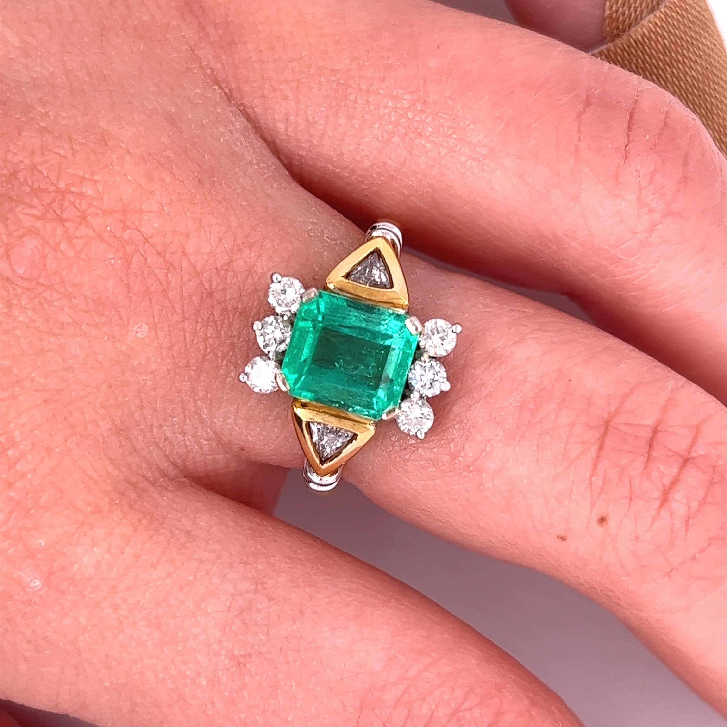 2.77-carat Emerald-cut Colombian Emerald mounted in 18k solid yellow gold ring setting with trillion-cut diamond accents. A superb quality Emerald with a vivid, 