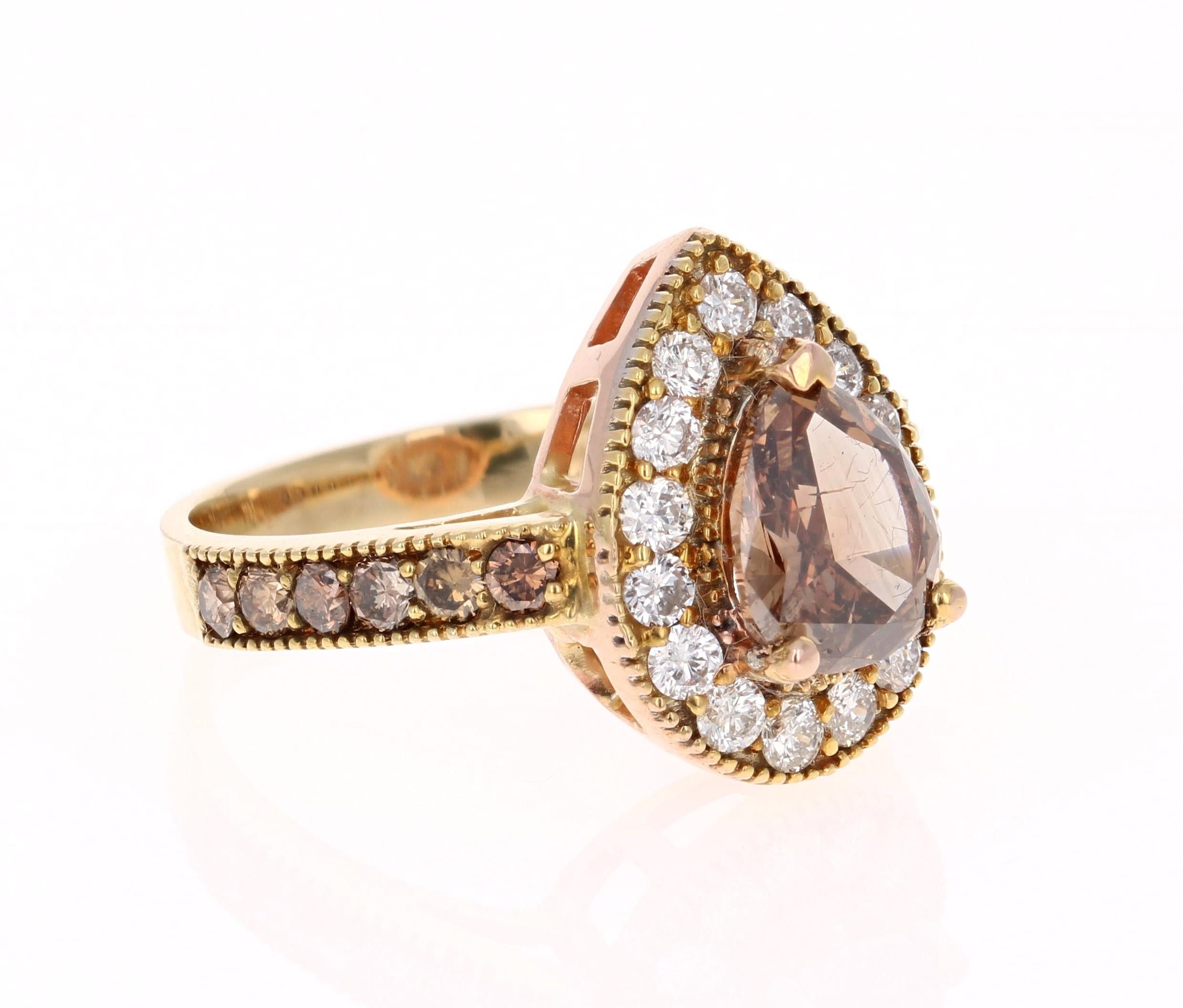 This beauty has a deep Brown/Champagne colored natural Pear Cut Diamond that weighs 1.68 Carats. It is surrounded by a halo of 15 Round Cut Diamonds that weigh 0.57 Carats. The clarity and color of the diamonds are SI1-G. The sides of the ring have
