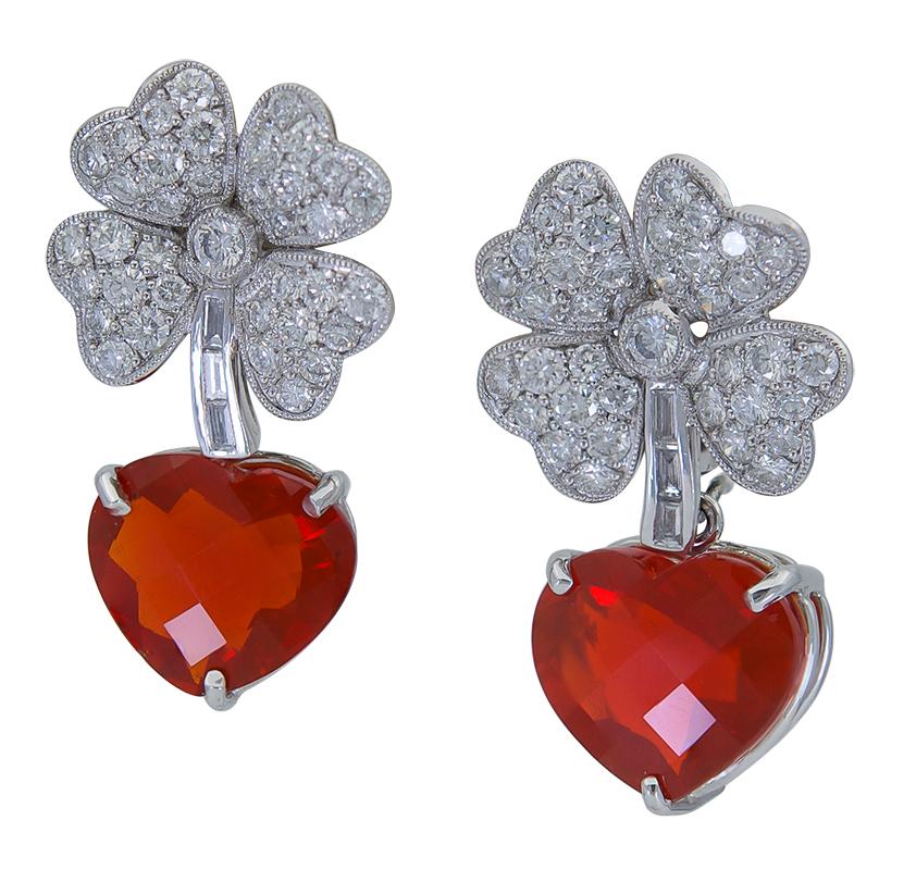 Showcasing a beautiful heart shape Mexican fire opal suspended on a brilliant four leaf clover accented with round diamonds. Made in 18k white gold. A piece that should give you luck indeed. 
Heart Shape weighs 27.78 carats total.
Diamonds weigh