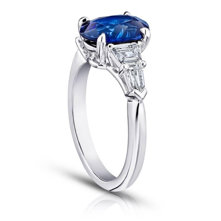 2.78 carat oval blue sapphire set with two trapezoid diamonds weighing .45 carats and two bullet diamonds weighing .29 carats set in a platinum ring
